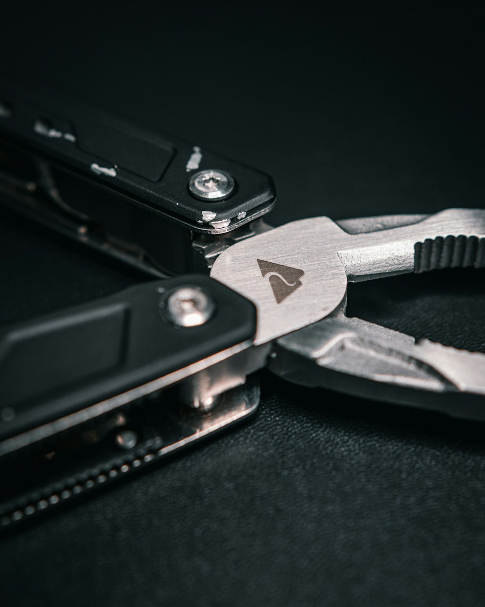 a pair of pliers are open on a black surface