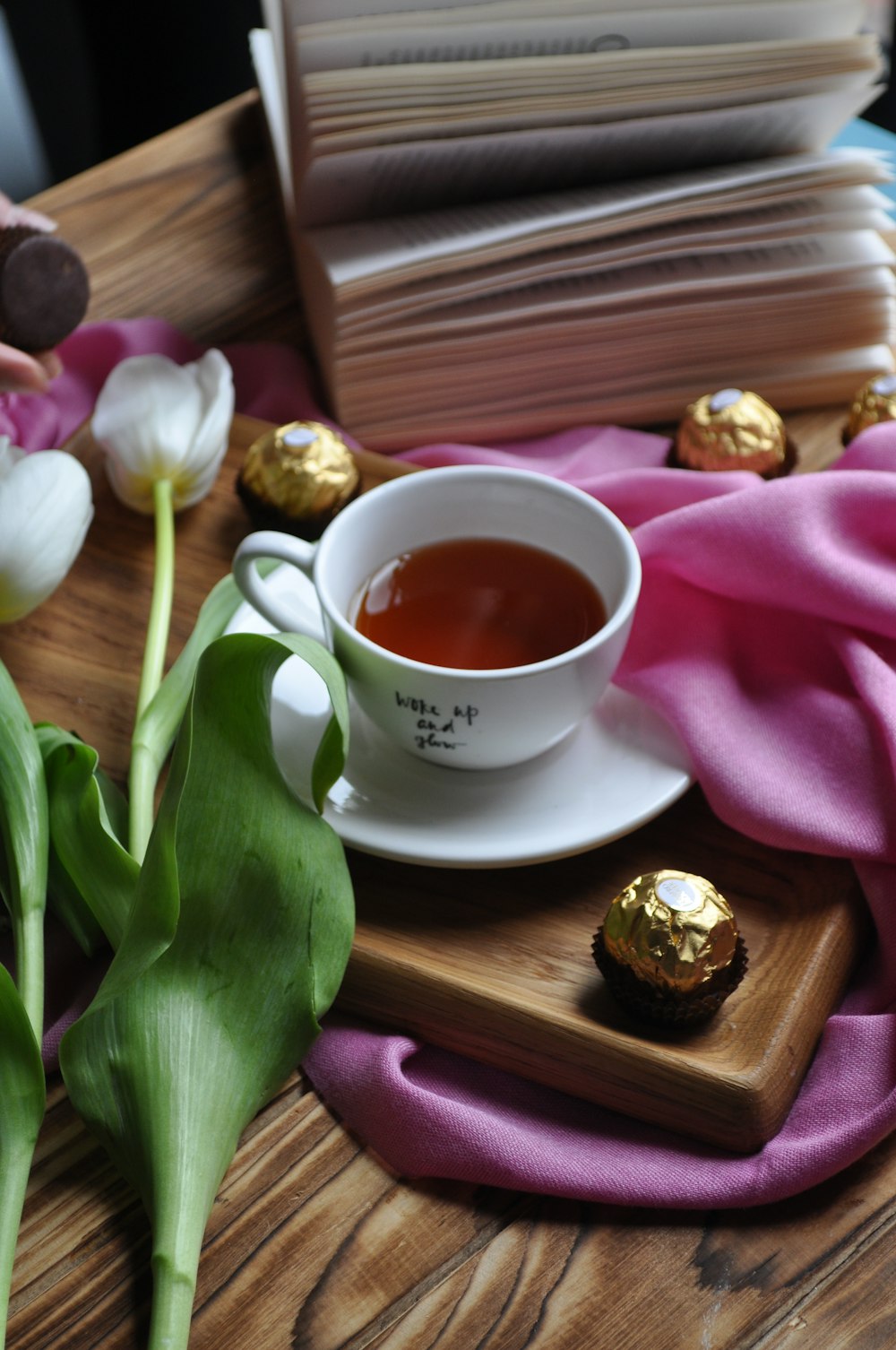 a cup of tea and some chocolates on a table