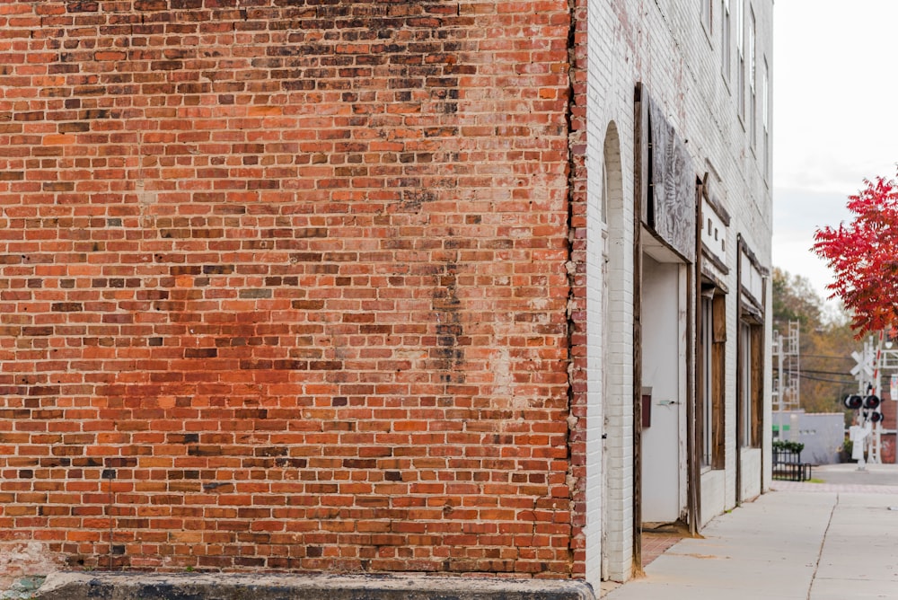 a red fire hydrant sitting on the side of a brick building