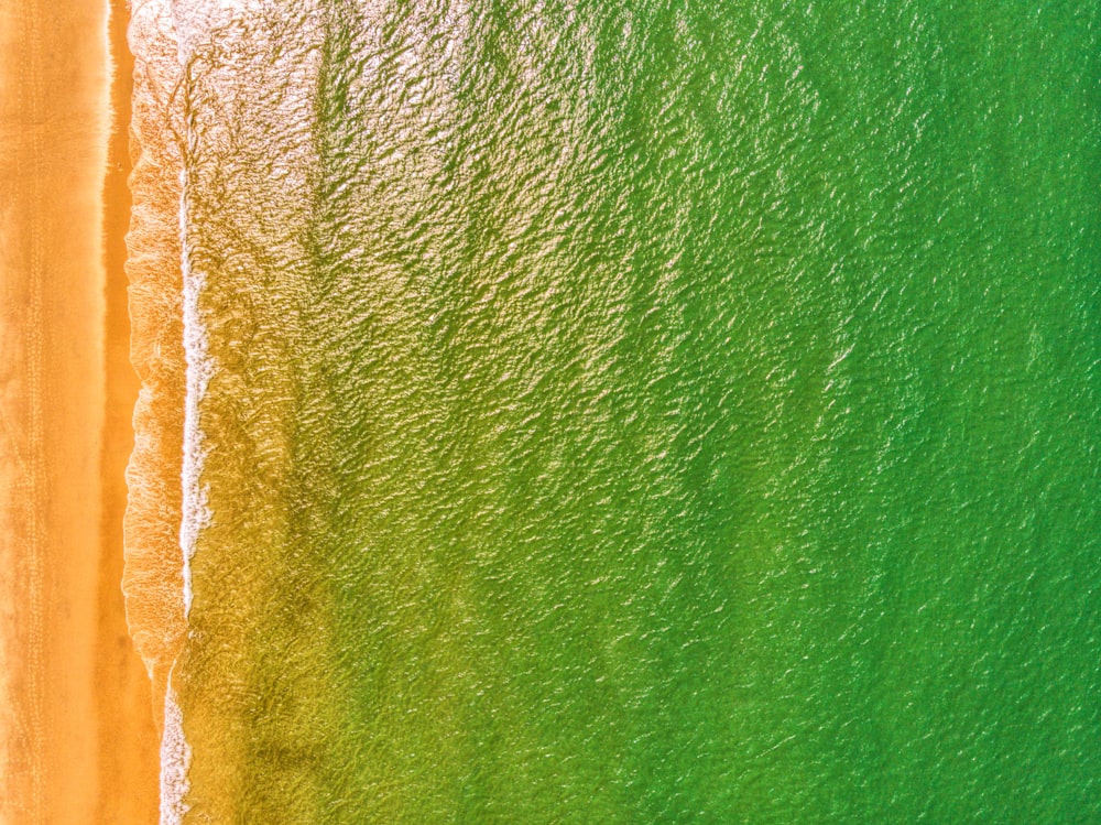 an aerial view of a beach with green water