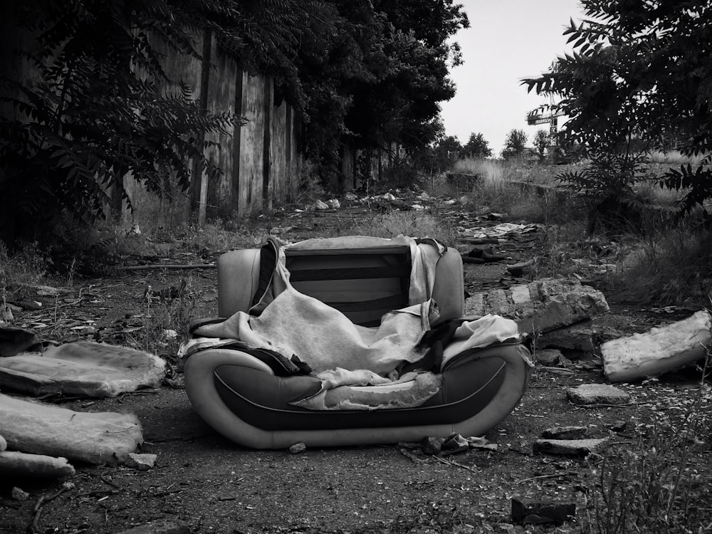 a black and white photo of a chair with a blanket on it