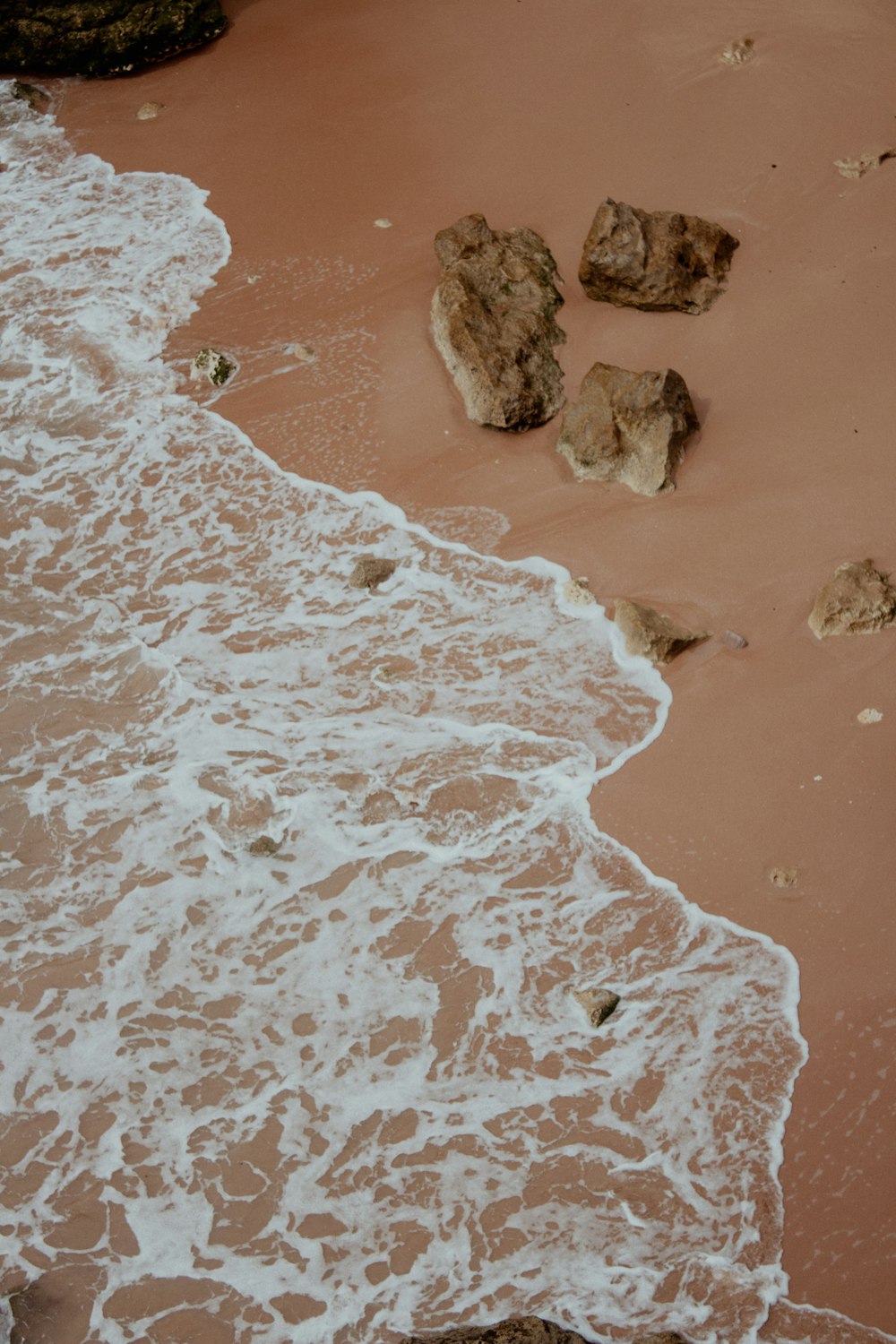 a sandy beach with waves coming in to shore