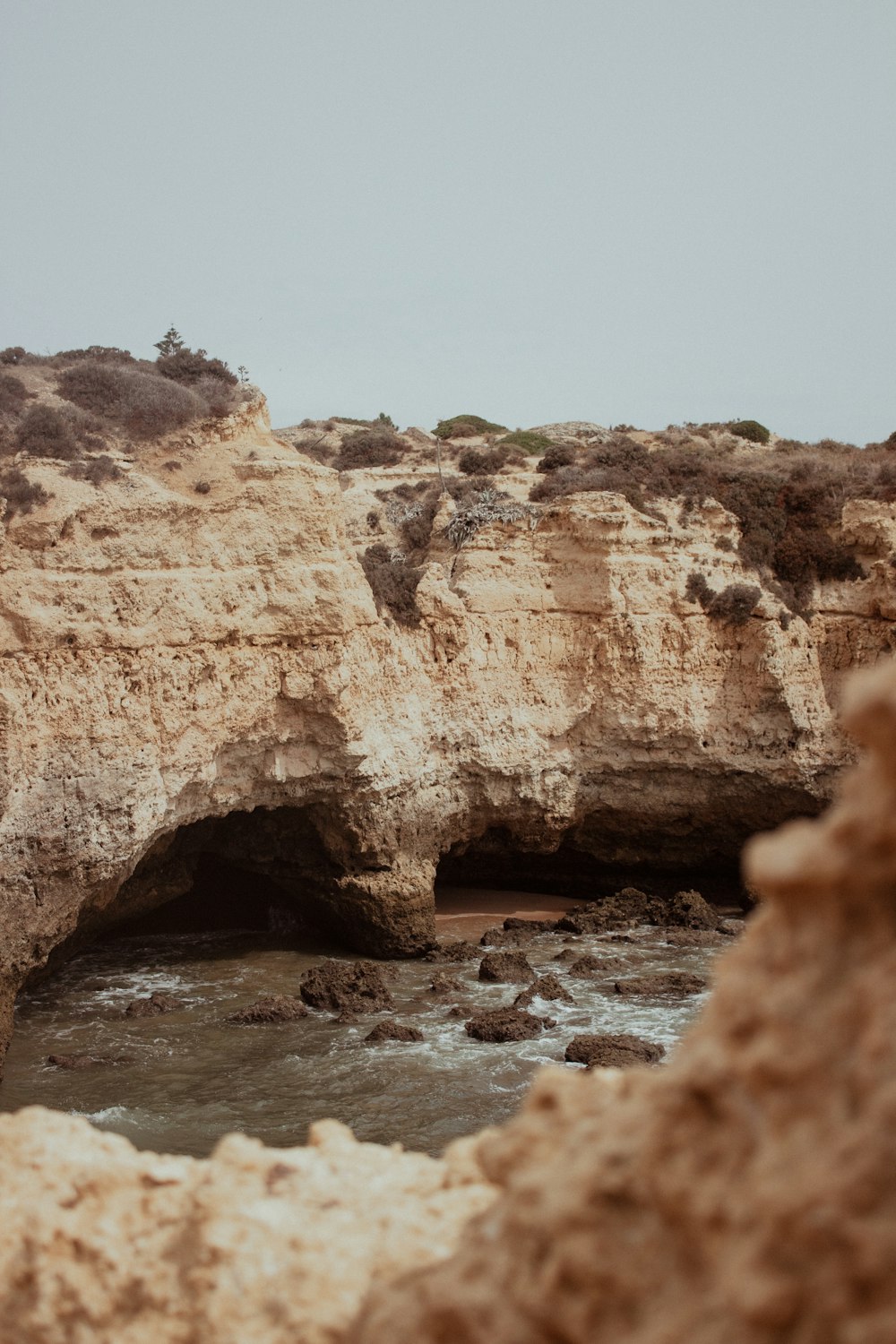 a man standing on a cliff next to a body of water