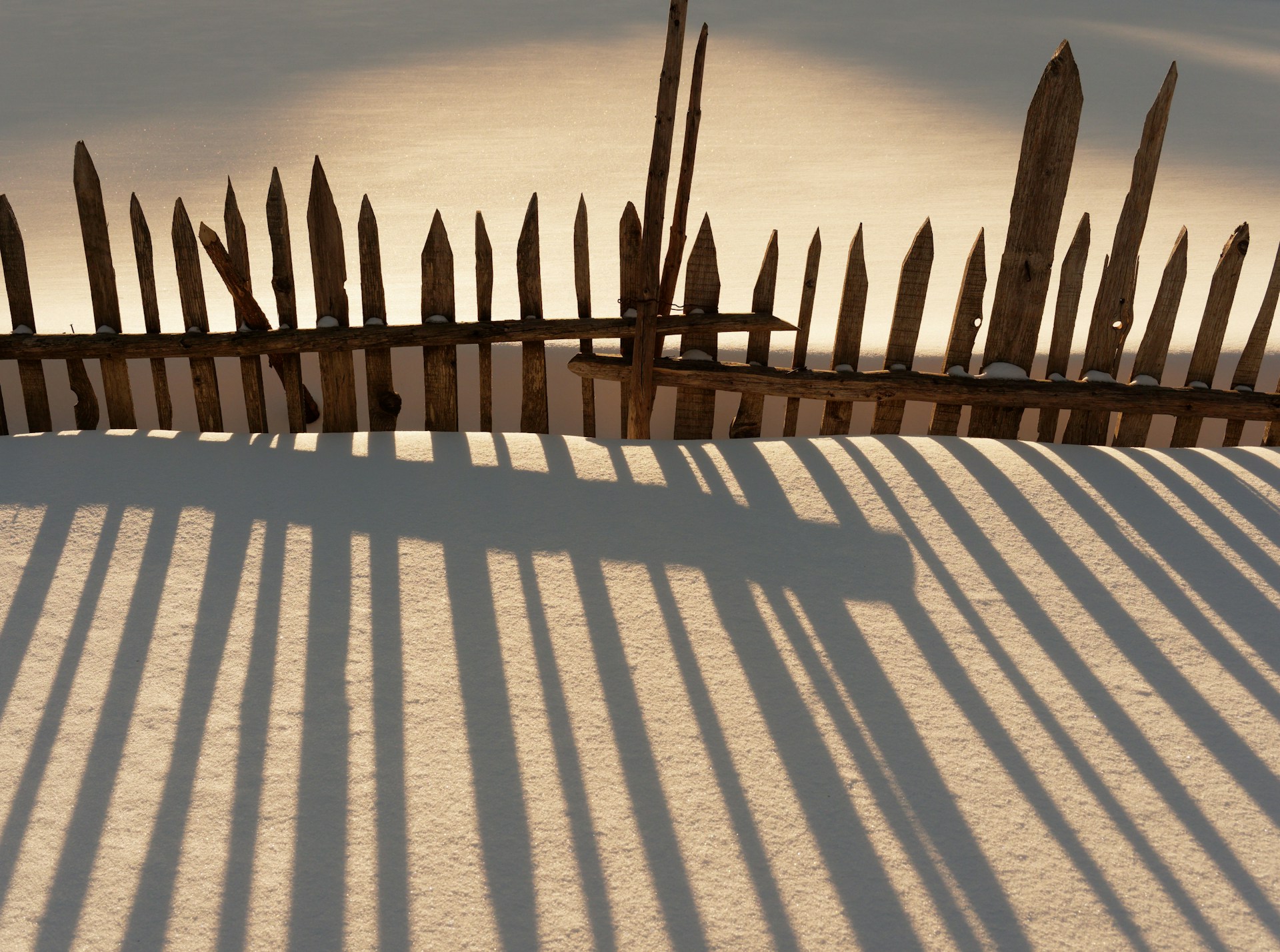 a wooden fence and a snow covered ground
