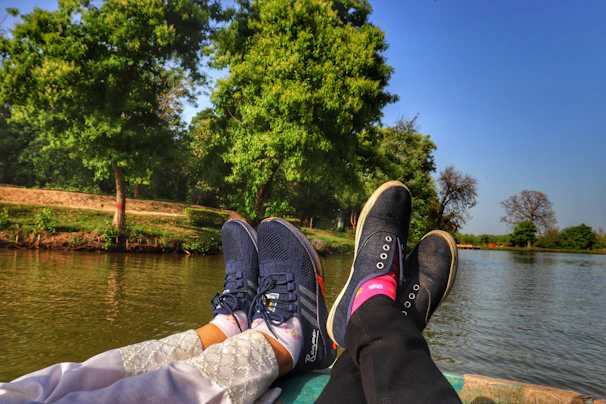 A pair of running shoes resting beside a peaceful lakeside path, symbolizing progress and movement.