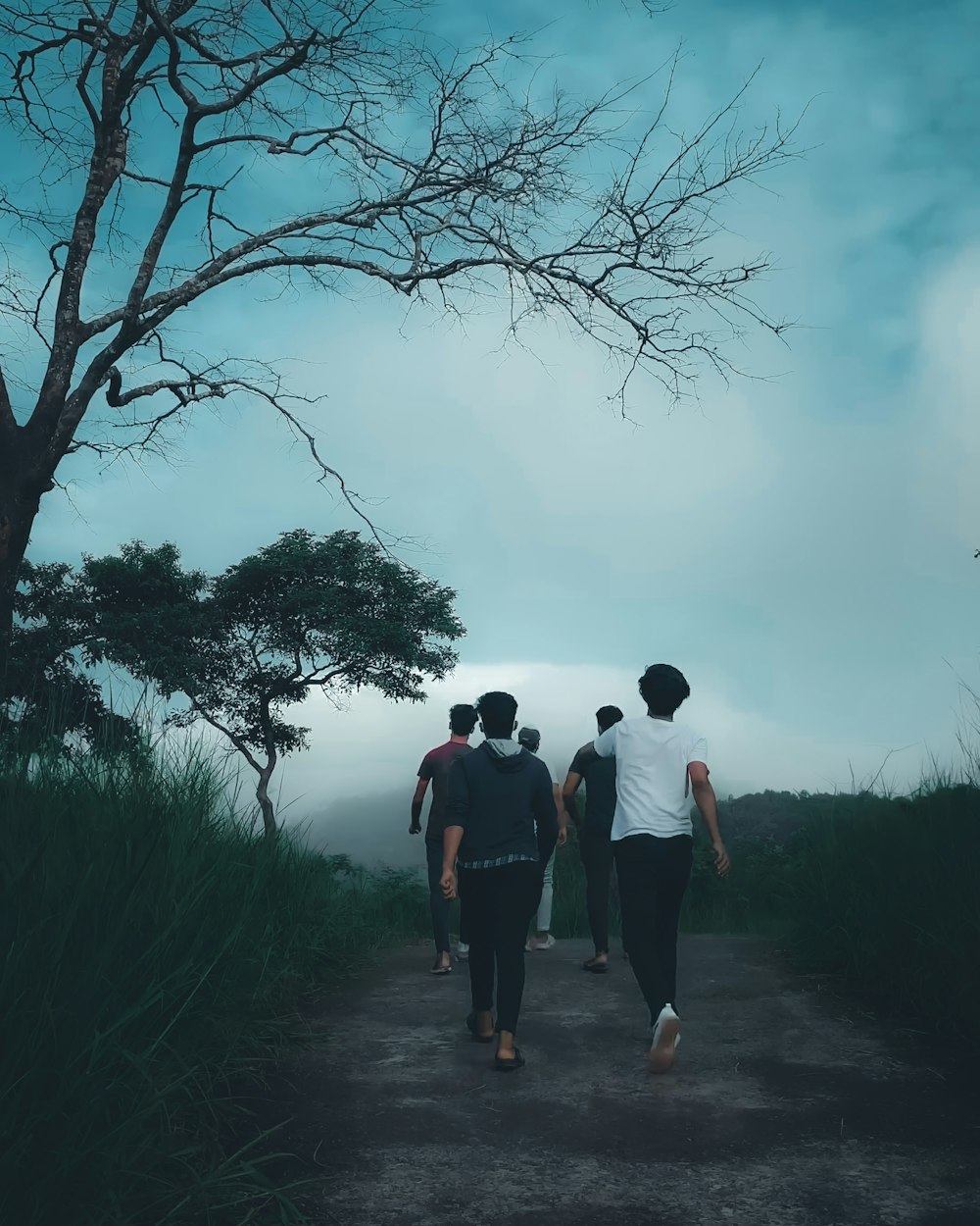 a group of people walking down a dirt road