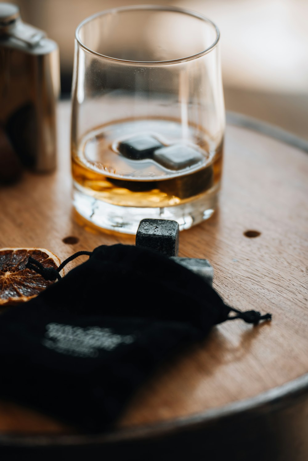 a glass of whiskey sitting on top of a wooden table
