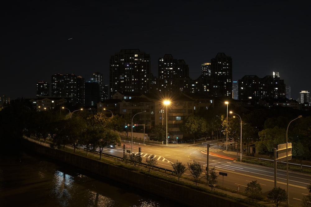 a city skyline at night with a river running through it