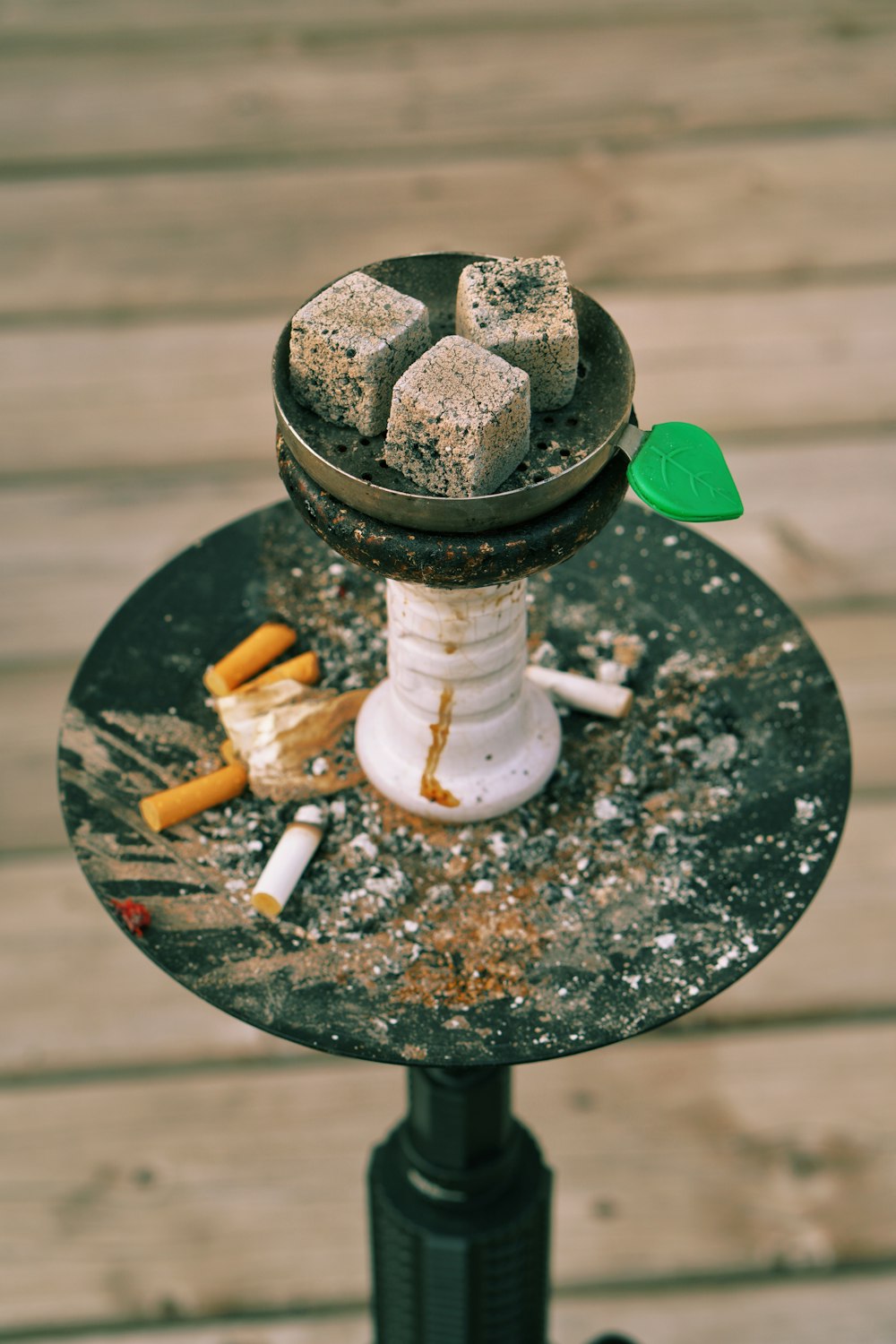 a table topped with a metal plate covered in cigarettes