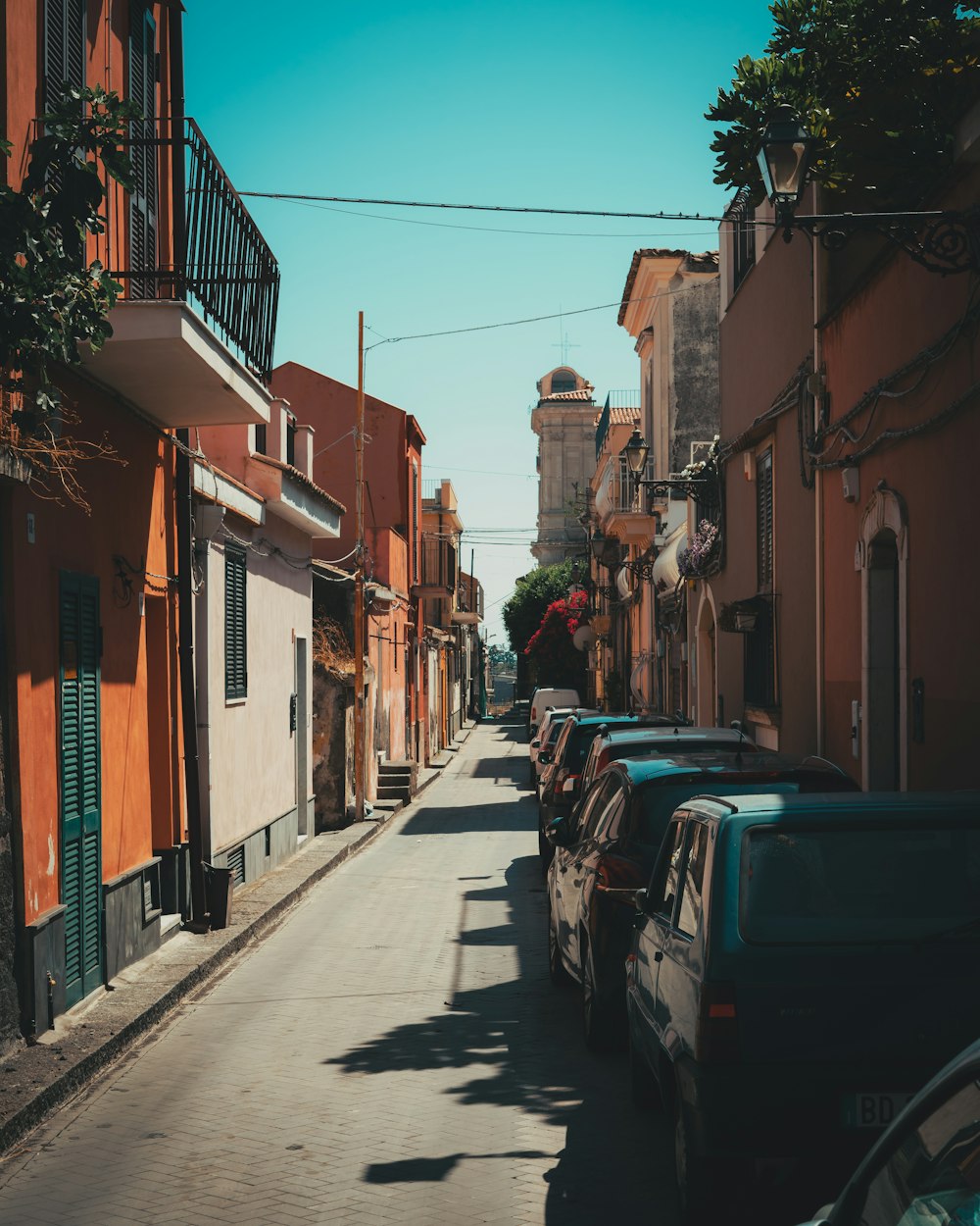 a street lined with parked cars next to tall buildings