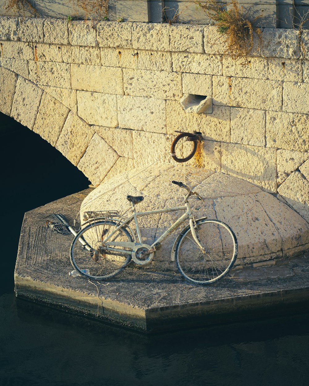 a bicycle parked next to a stone bridge