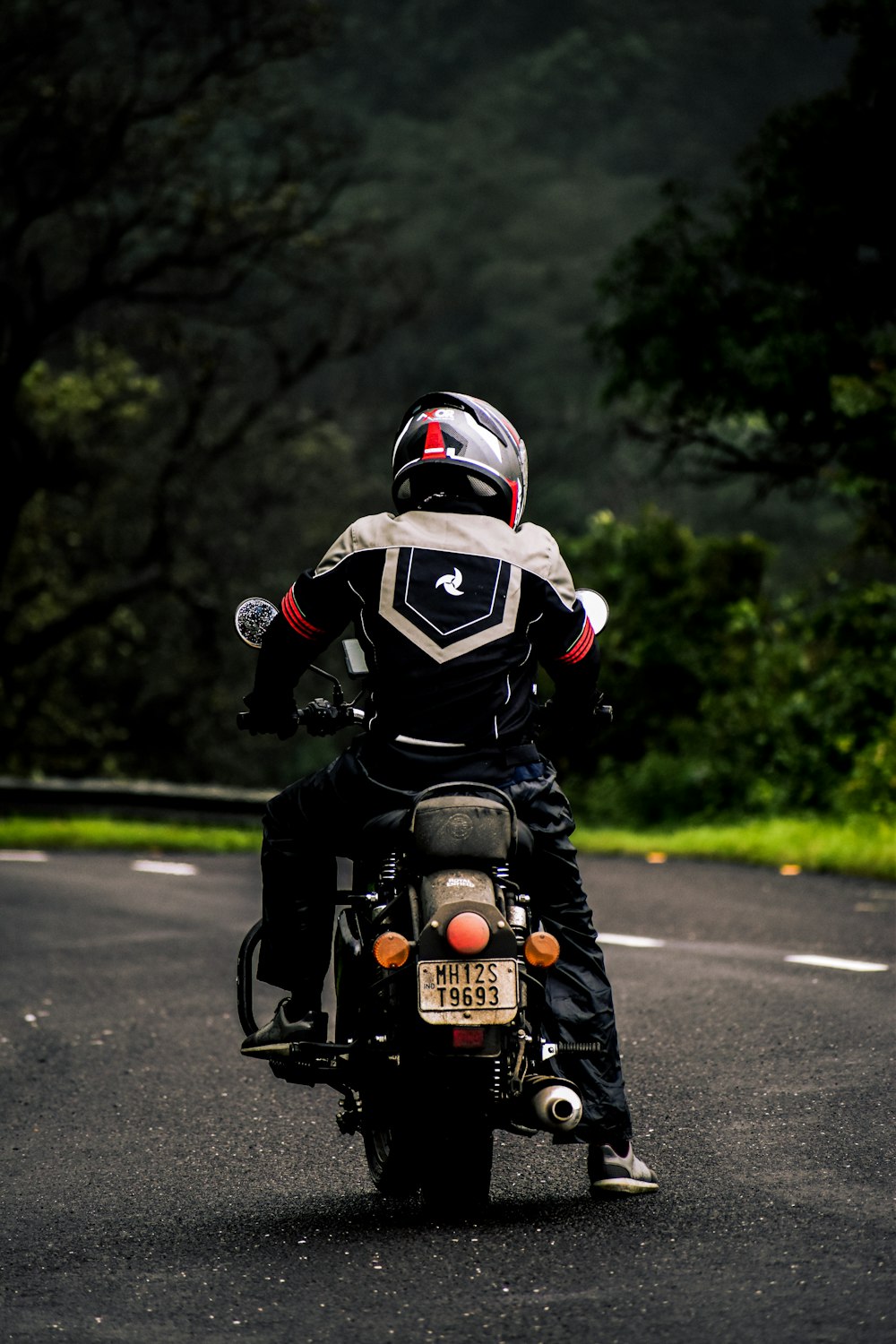 a man riding a motorcycle down a curvy road