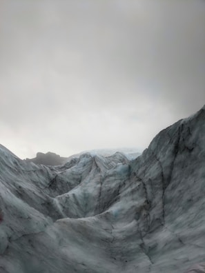 A panoramic view of rugged ice formations against a dark grey sky.