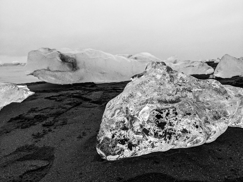 a large rock sitting on top of a black sand beach