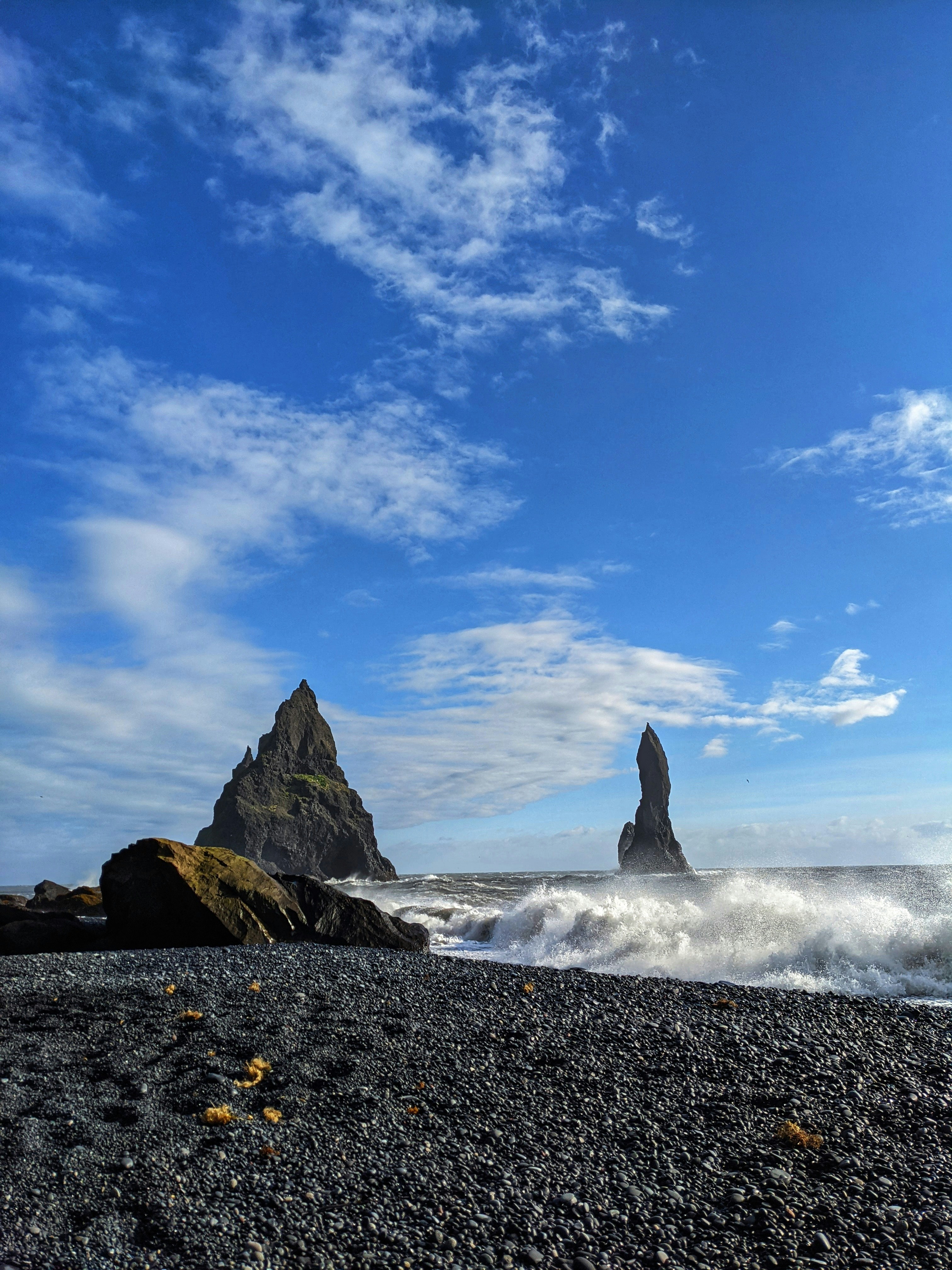 Foto Una playa rocosa con una formación rocosa al fondo – Imagen ...