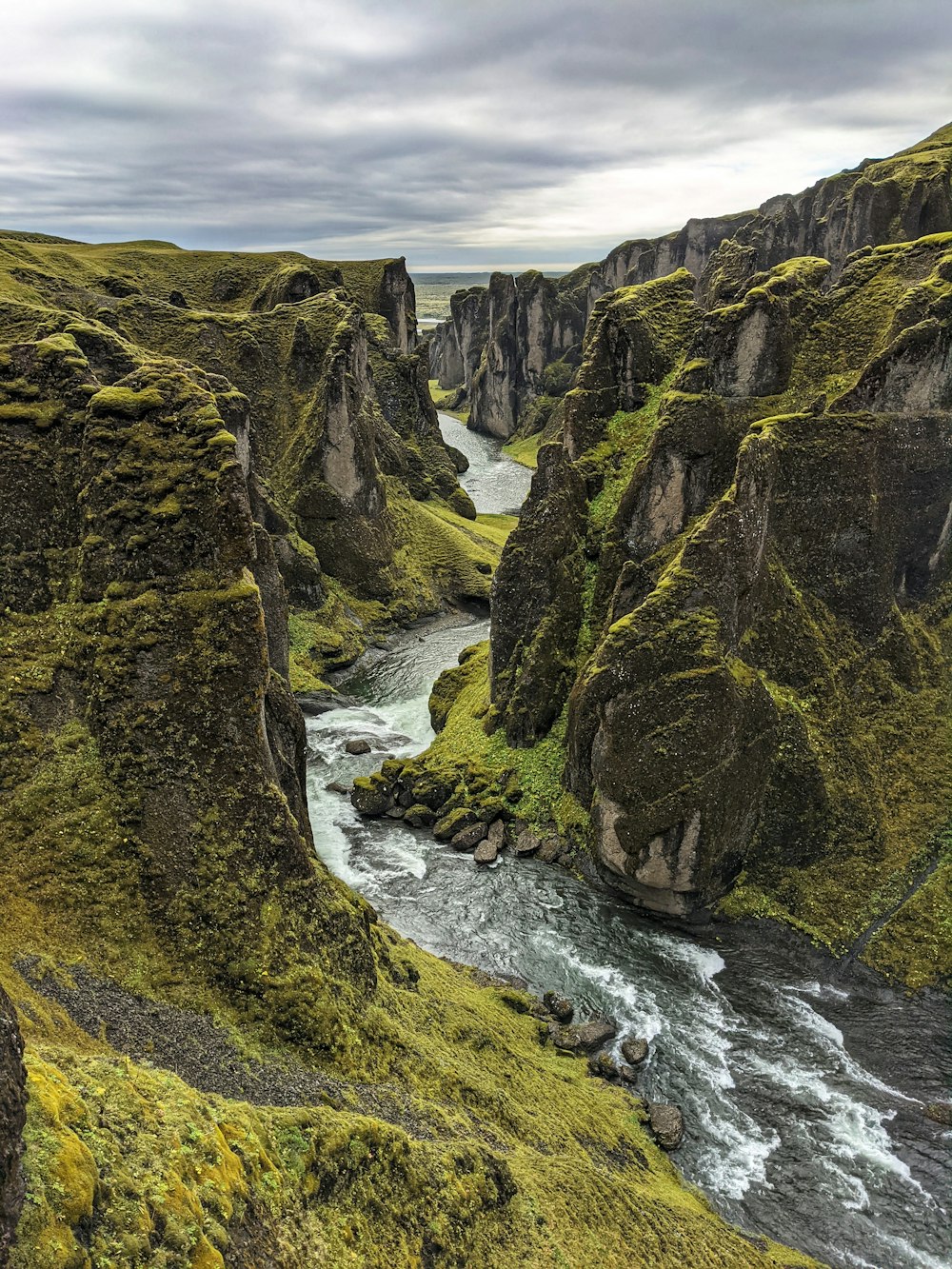 a river flowing through a lush green valley