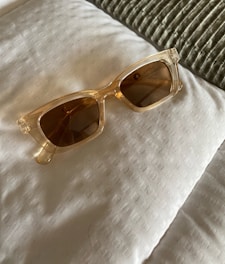 Close-up of trendy sunglasses resting on a textured fabric background.