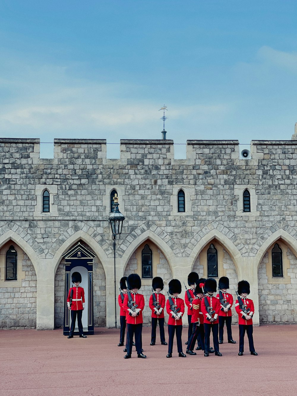 Un grupo de hombres uniformados parados frente a un castillo