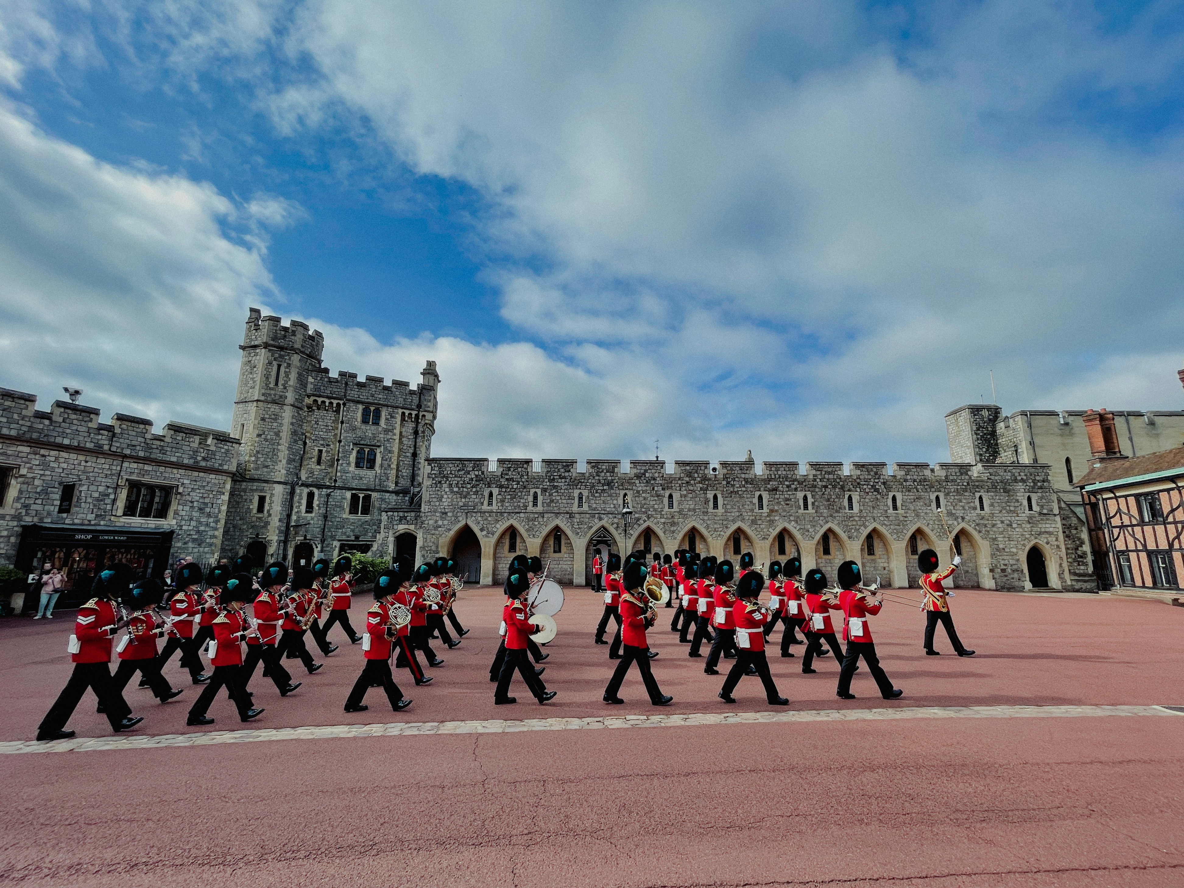 a group of men in red uniforms marching in front of a castle