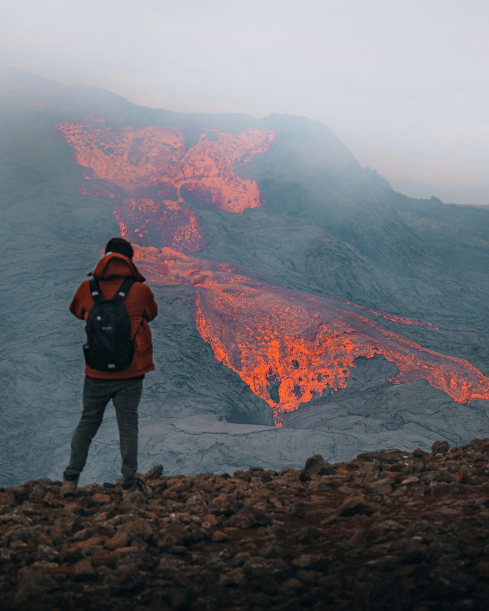 a man standing on top of a rocky hillside