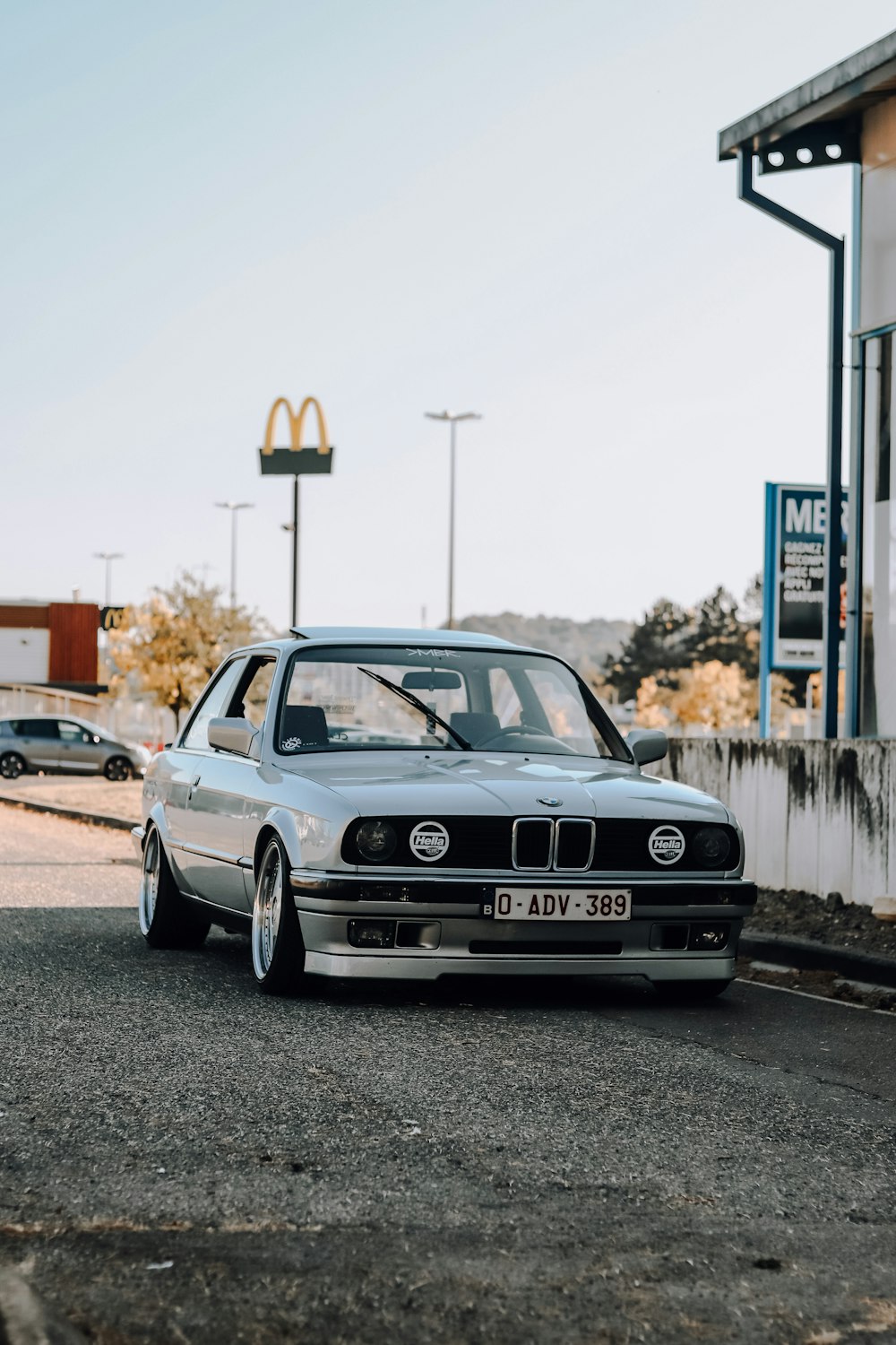 a silver car parked in front of a mcdonald's