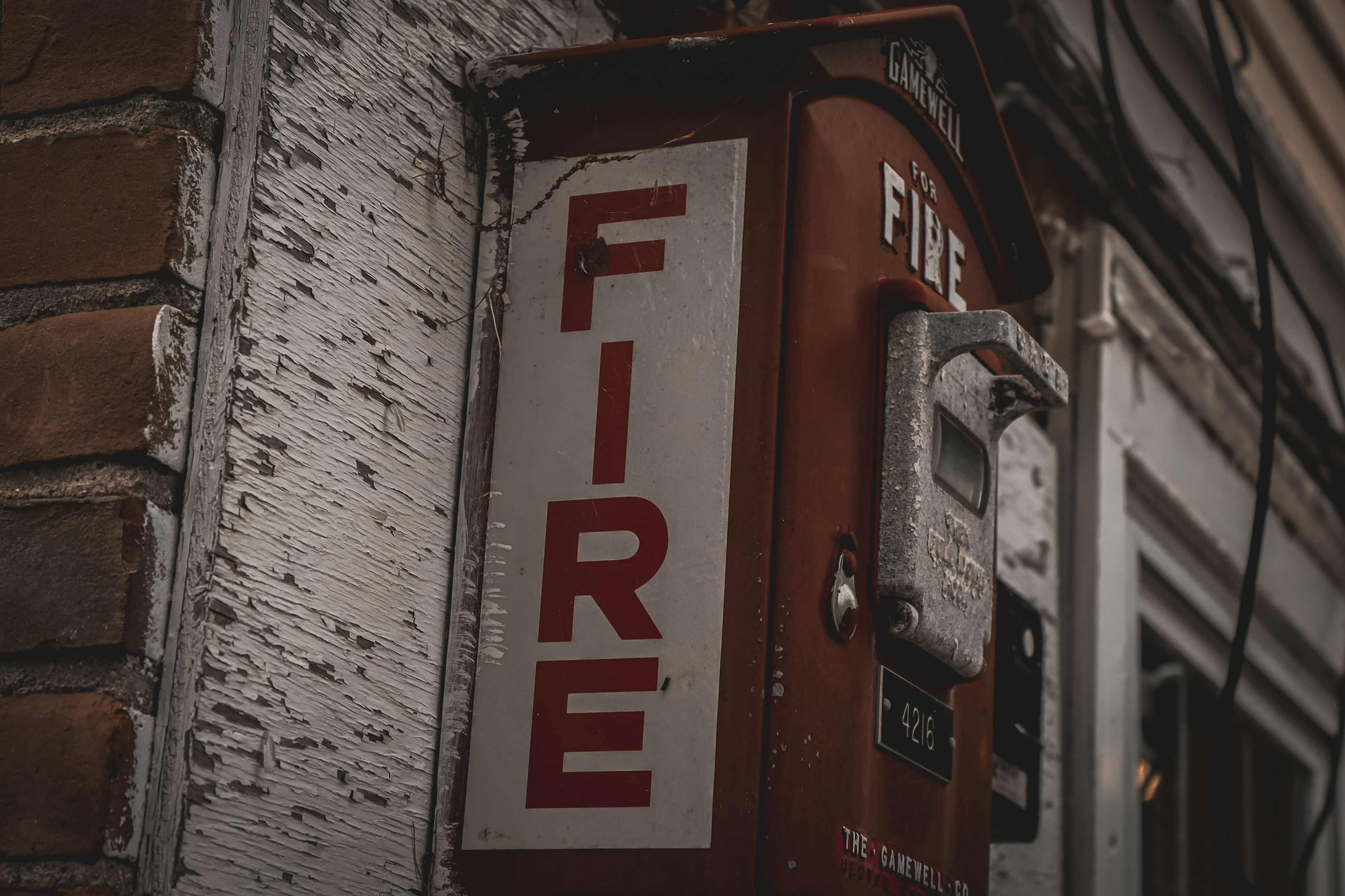 a red and white fire extinguisher next to a brick building