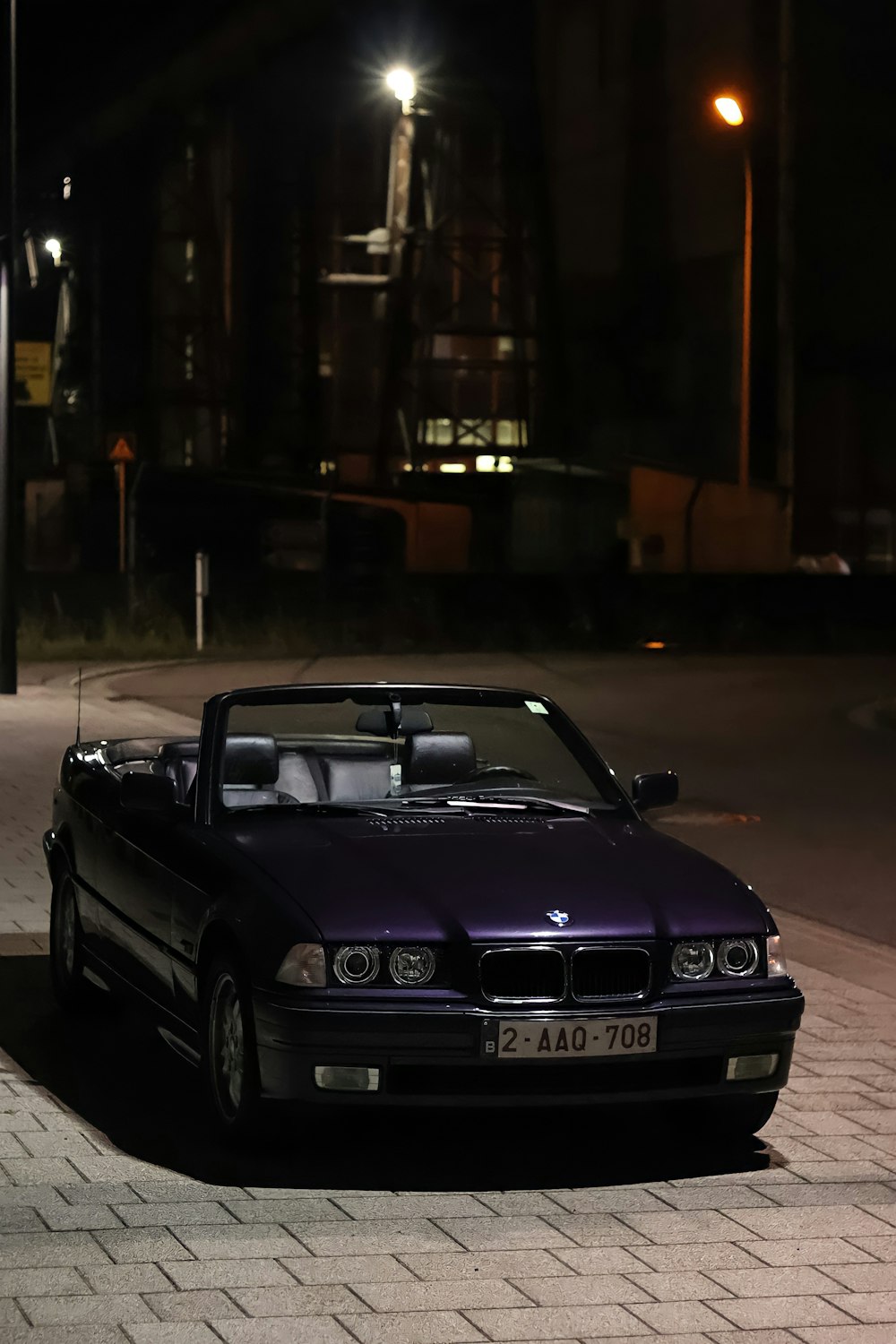 a purple convertible car parked on the side of the road