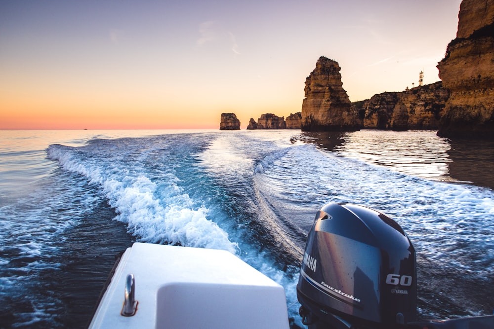 a boat traveling through a body of water at sunset