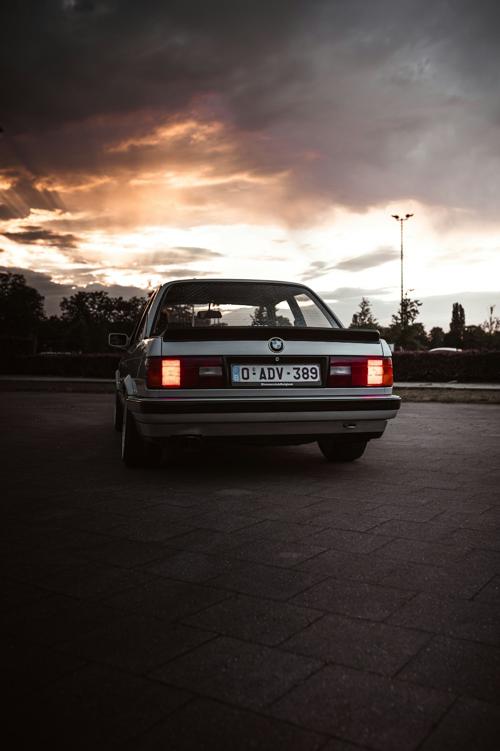 a car parked in a parking lot under a cloudy sky