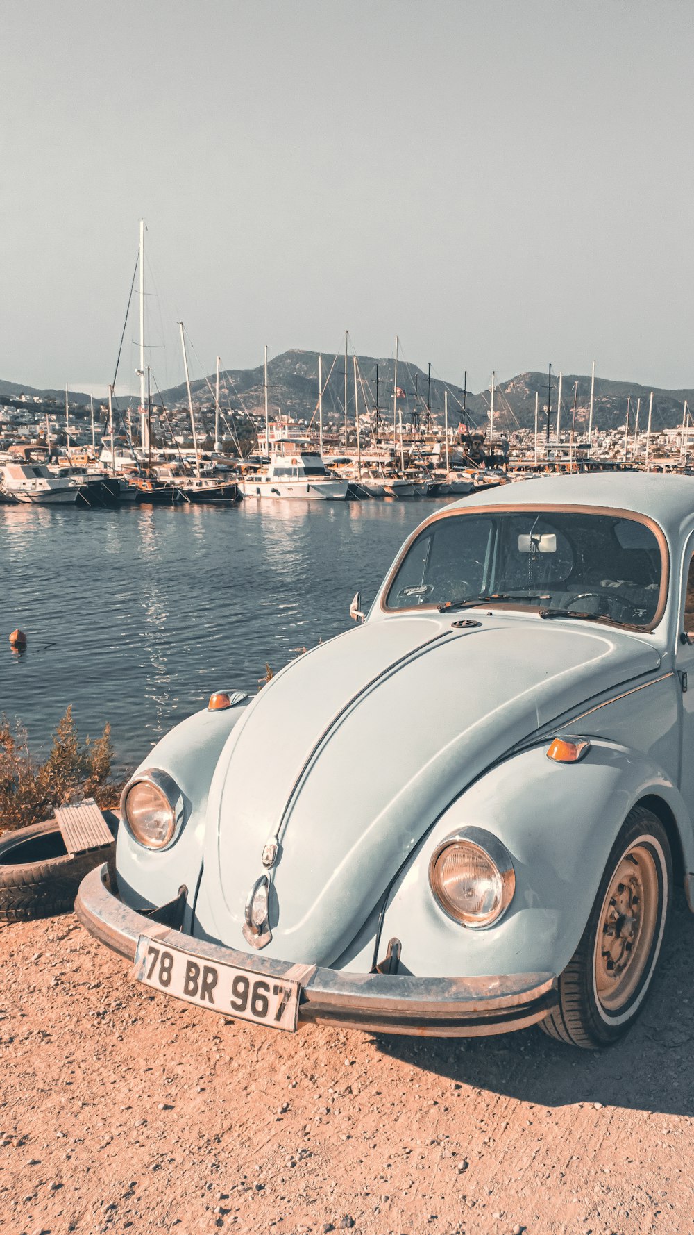 an old vw bug is parked on the beach