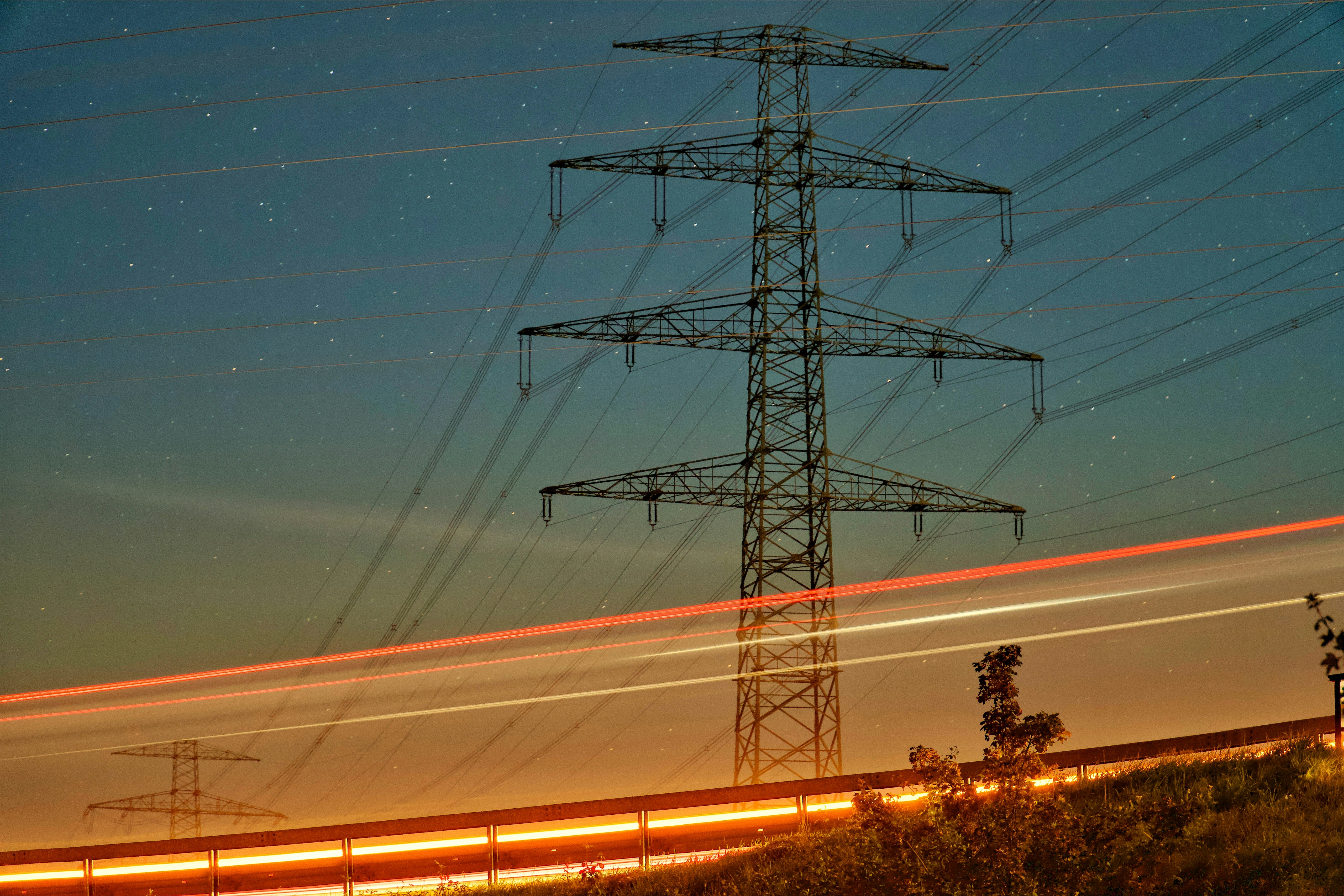 A high voltage power line with a train passing by photo Free Ilmenau