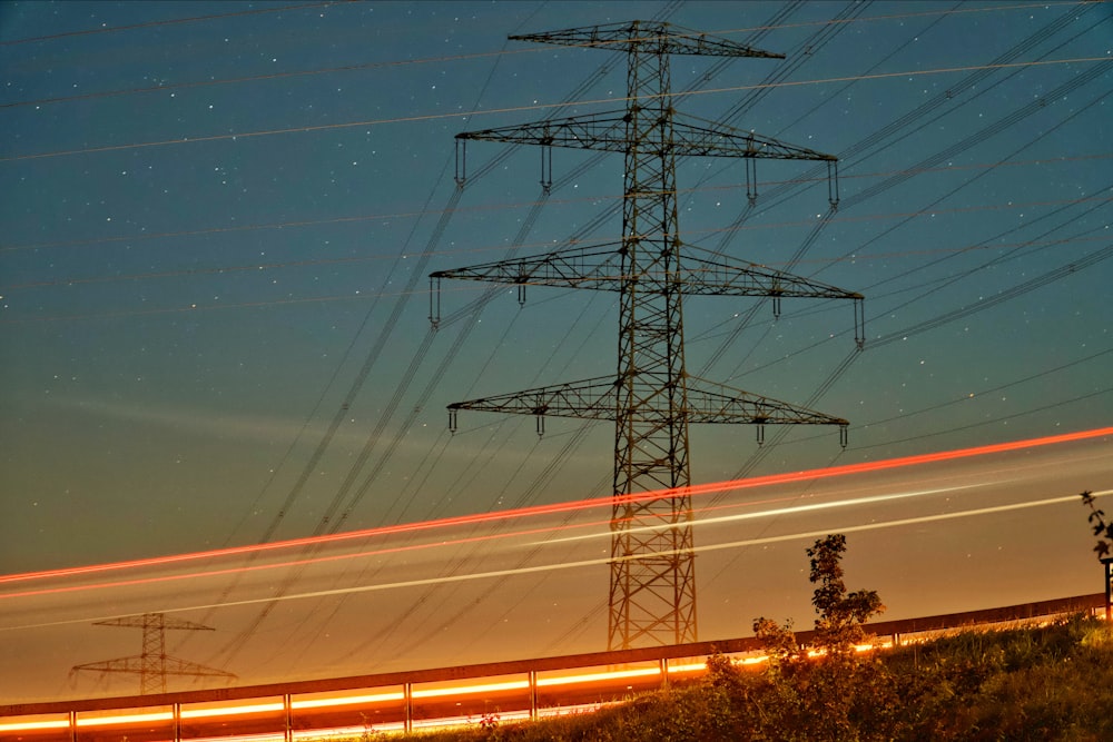 a high voltage power line with a train passing by