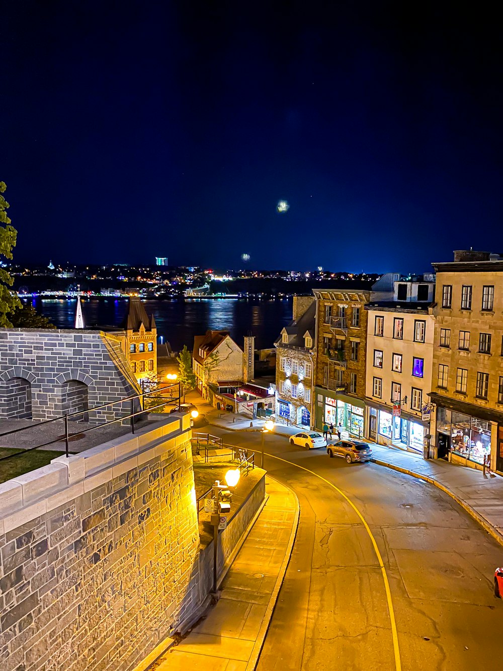 a city street at night with a clock tower in the background