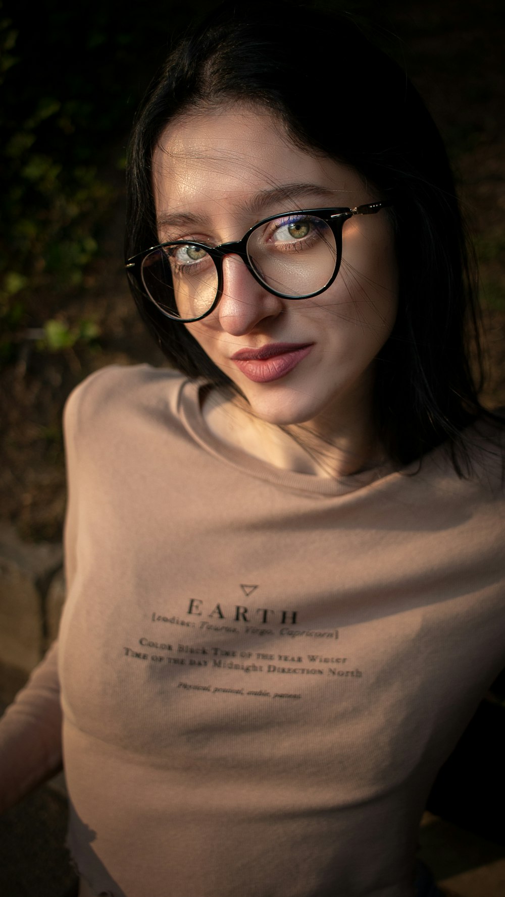 a woman wearing glasses is posing for a picture