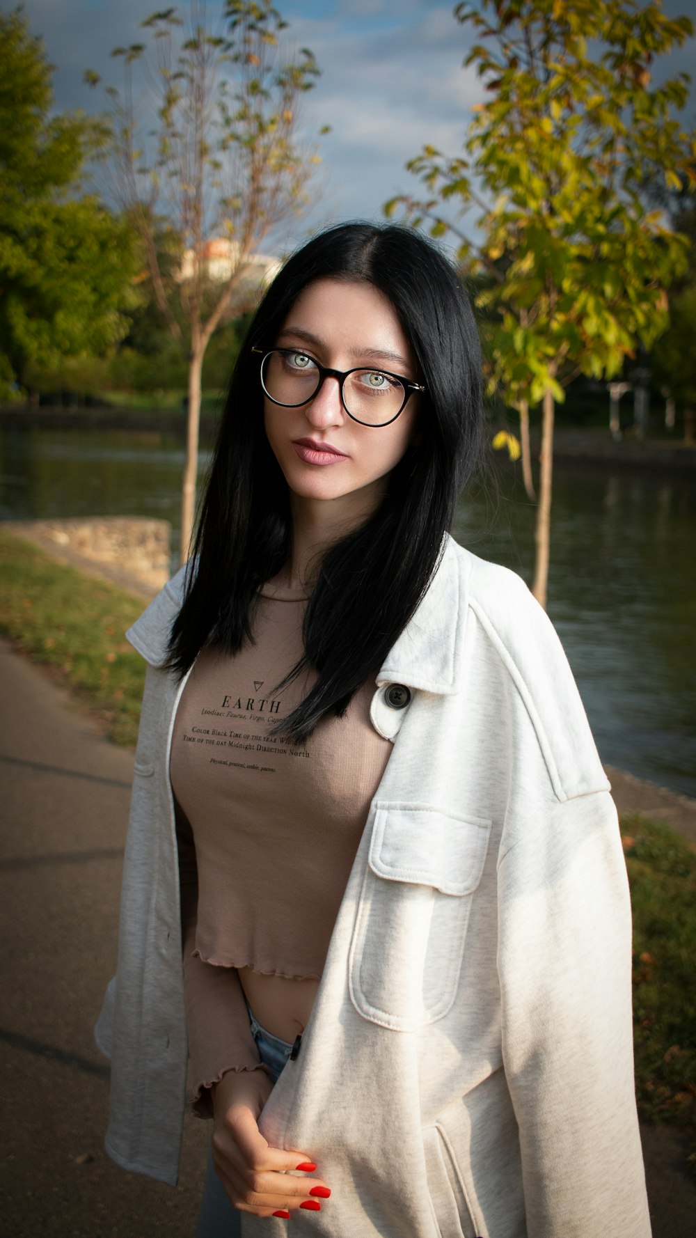 a woman wearing glasses and a white jacket