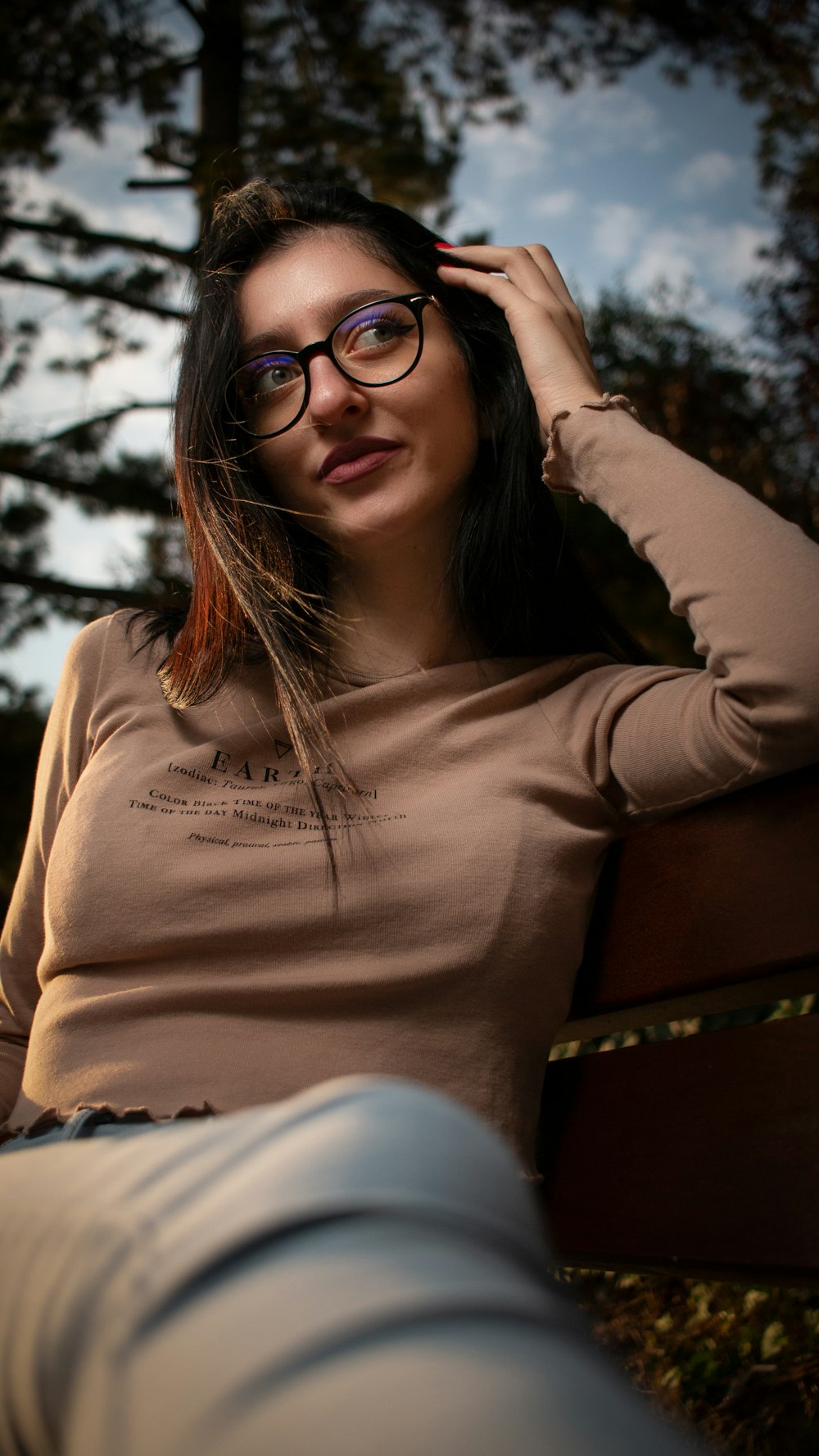 a woman wearing glasses sitting on a bench