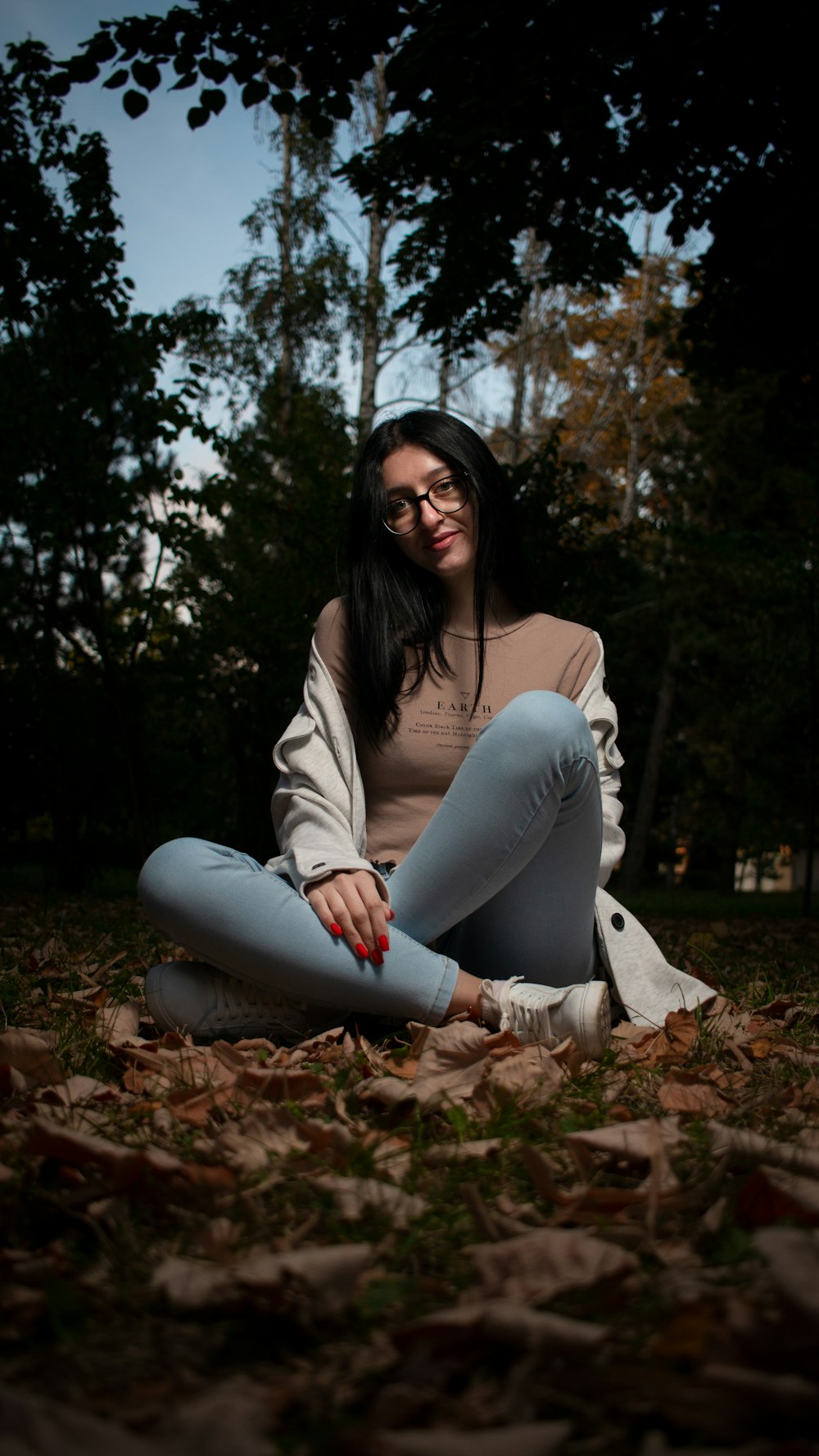 a woman sitting on the ground with her legs crossed