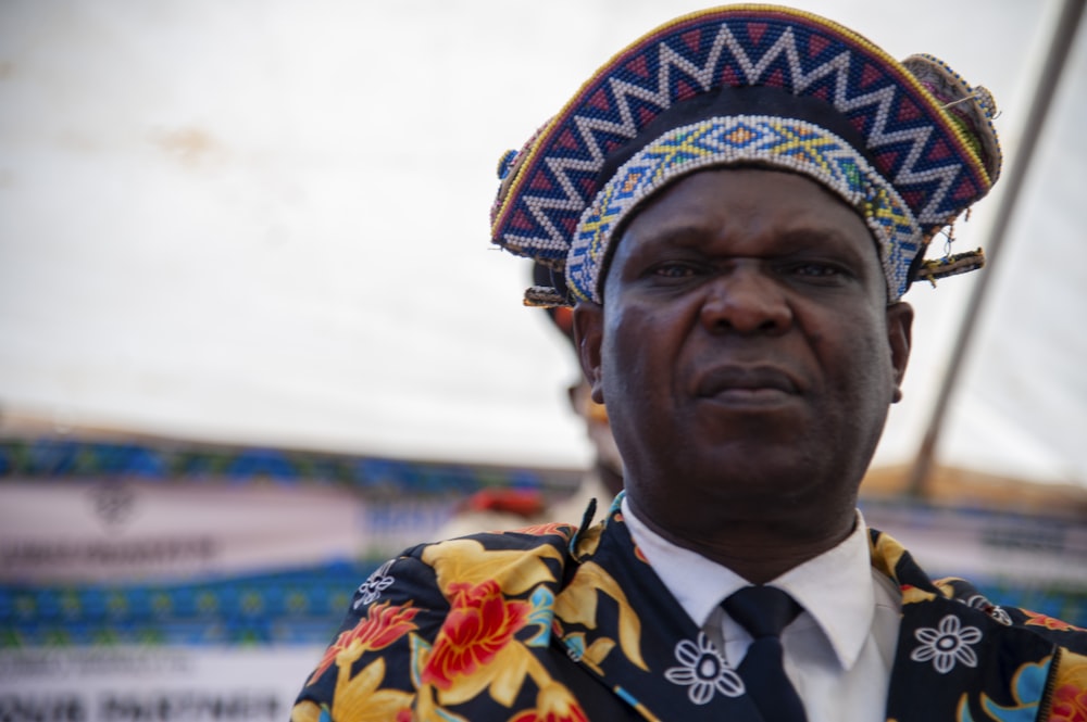 a man wearing a colorful head piece and a tie