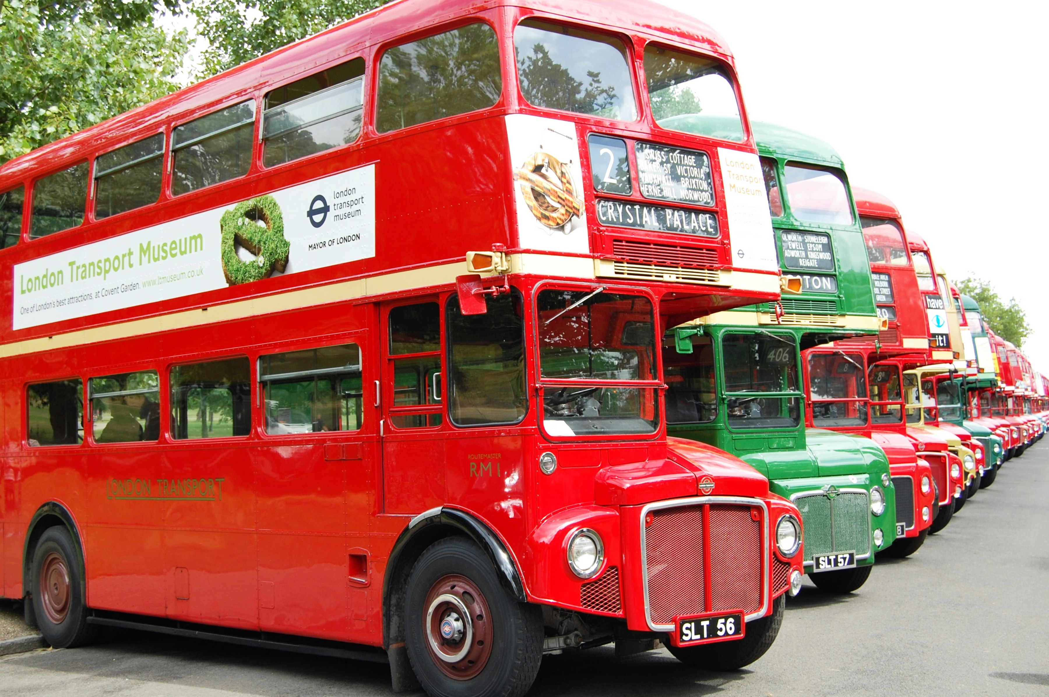 a row of red double decker buses parked next to each other
