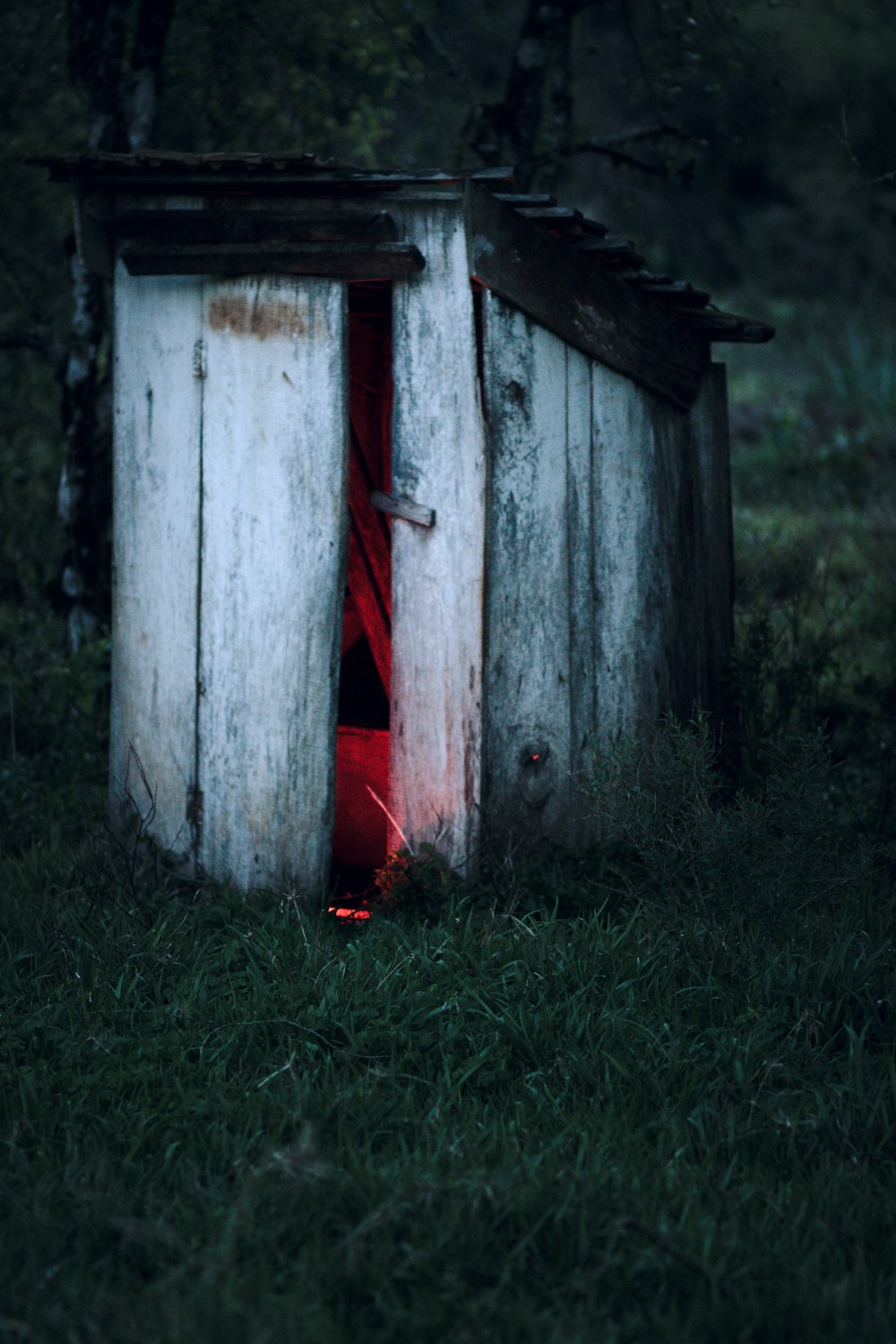 a outhouse with a red light coming out of it