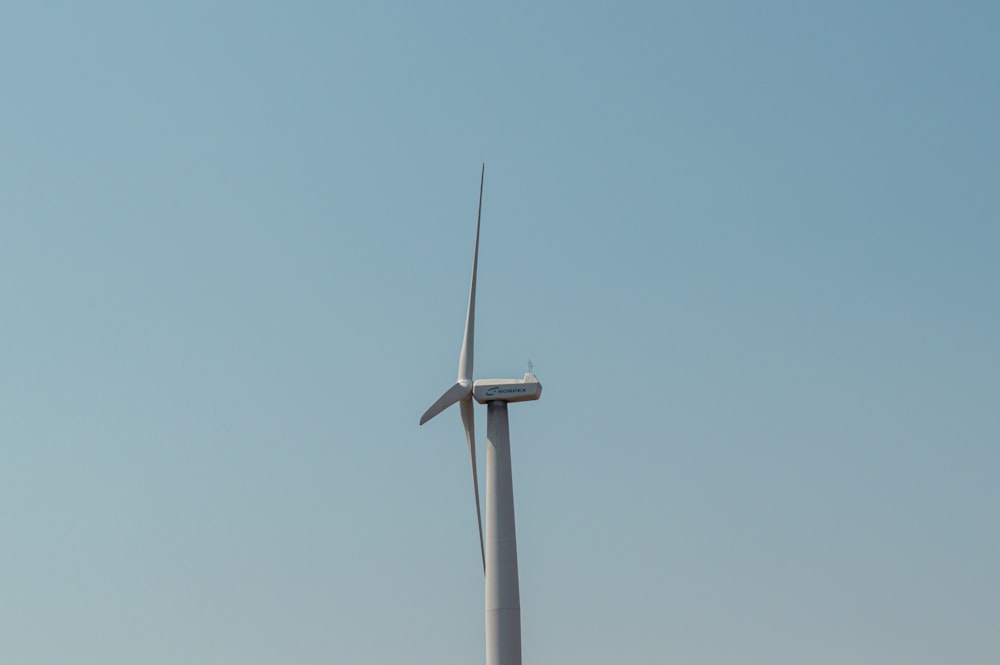 a wind turbine in the middle of a clear blue sky