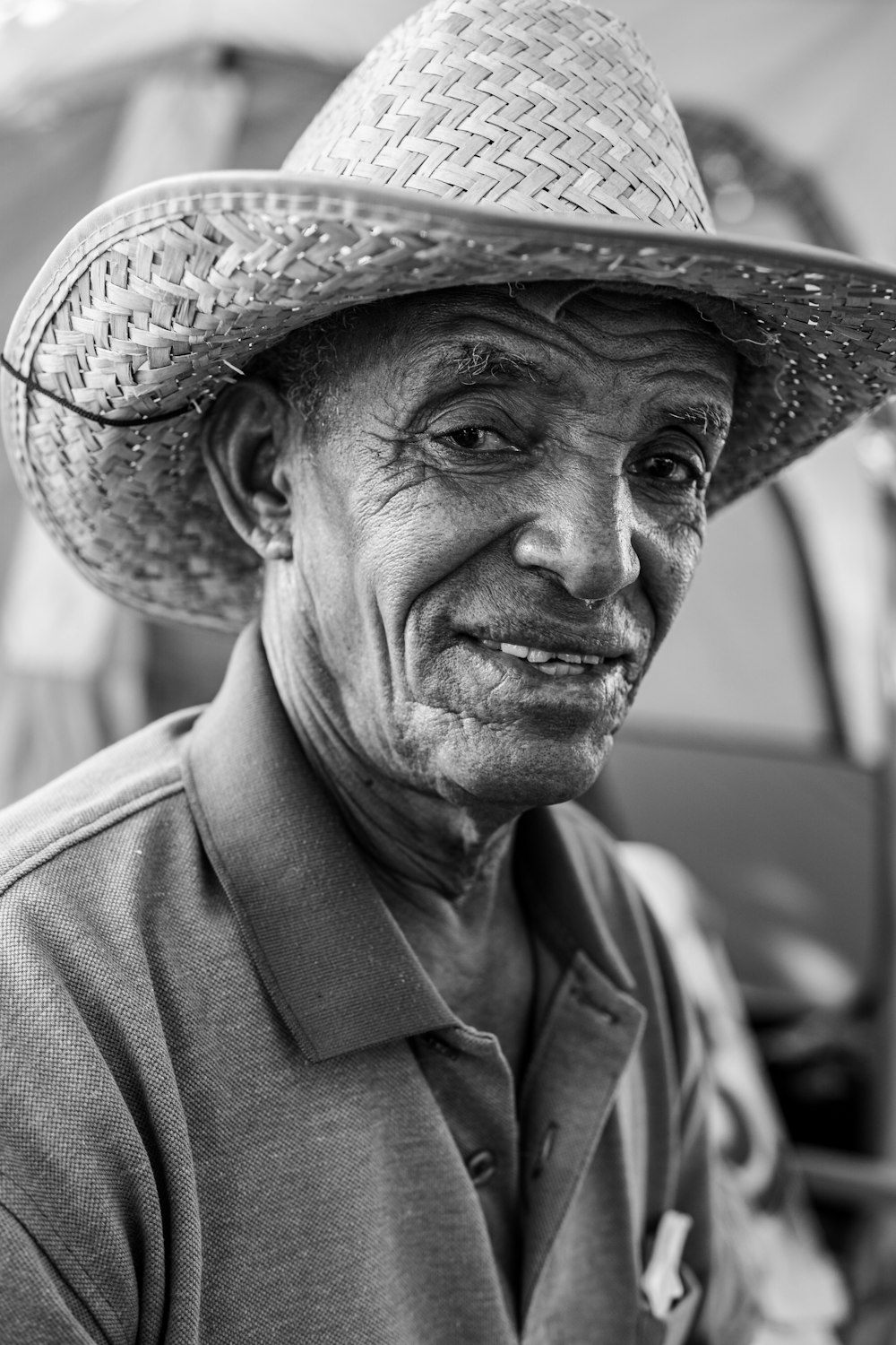 a black and white photo of a man wearing a straw hat