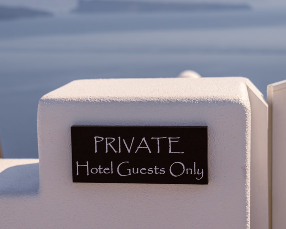 a private hotel guest only sign on a white wall