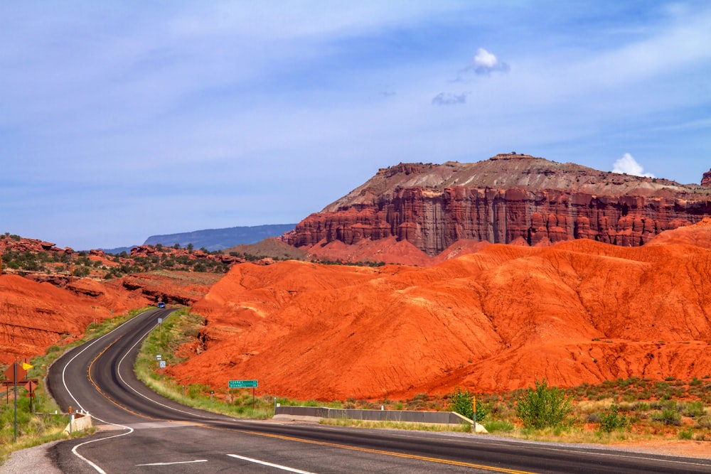 a road in the middle of the desert with a mountain in the background