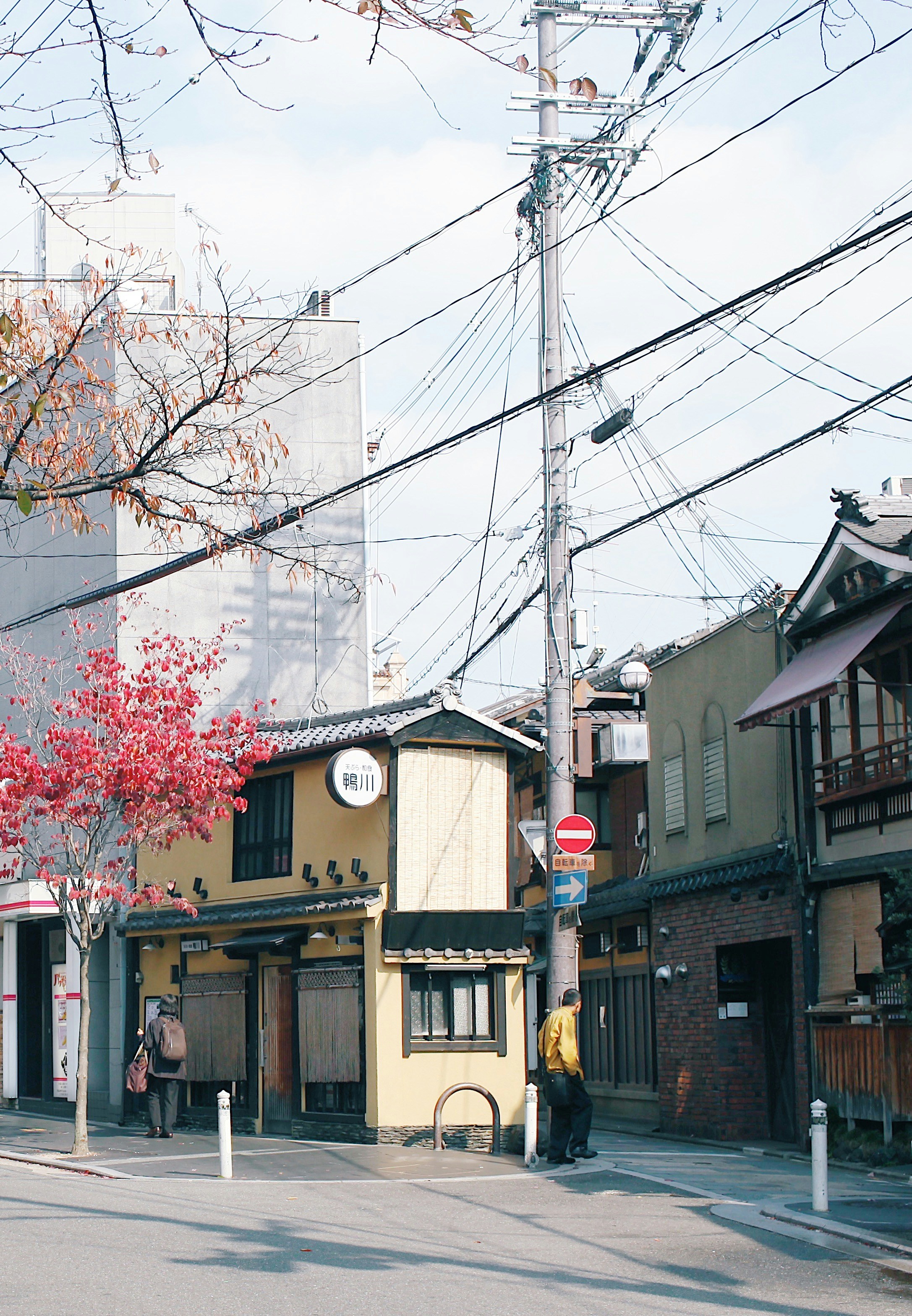 a street corner with a few buildings and power lines in the background