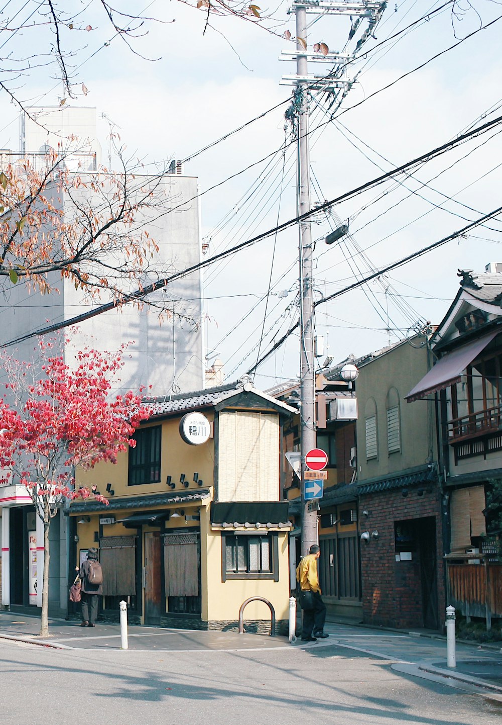 a street corner with a few buildings and power lines in the background