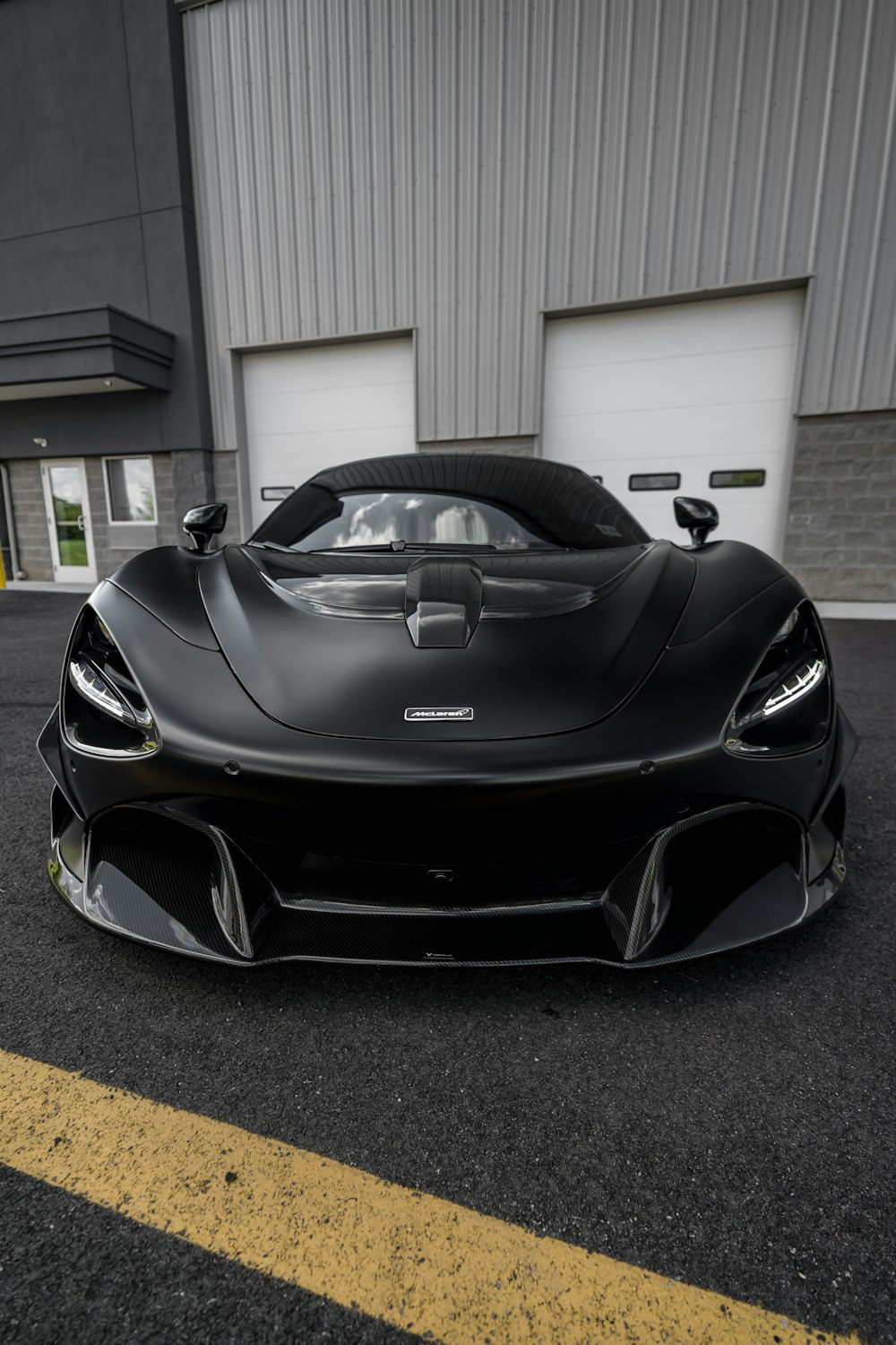 a black sports car parked in front of a garage