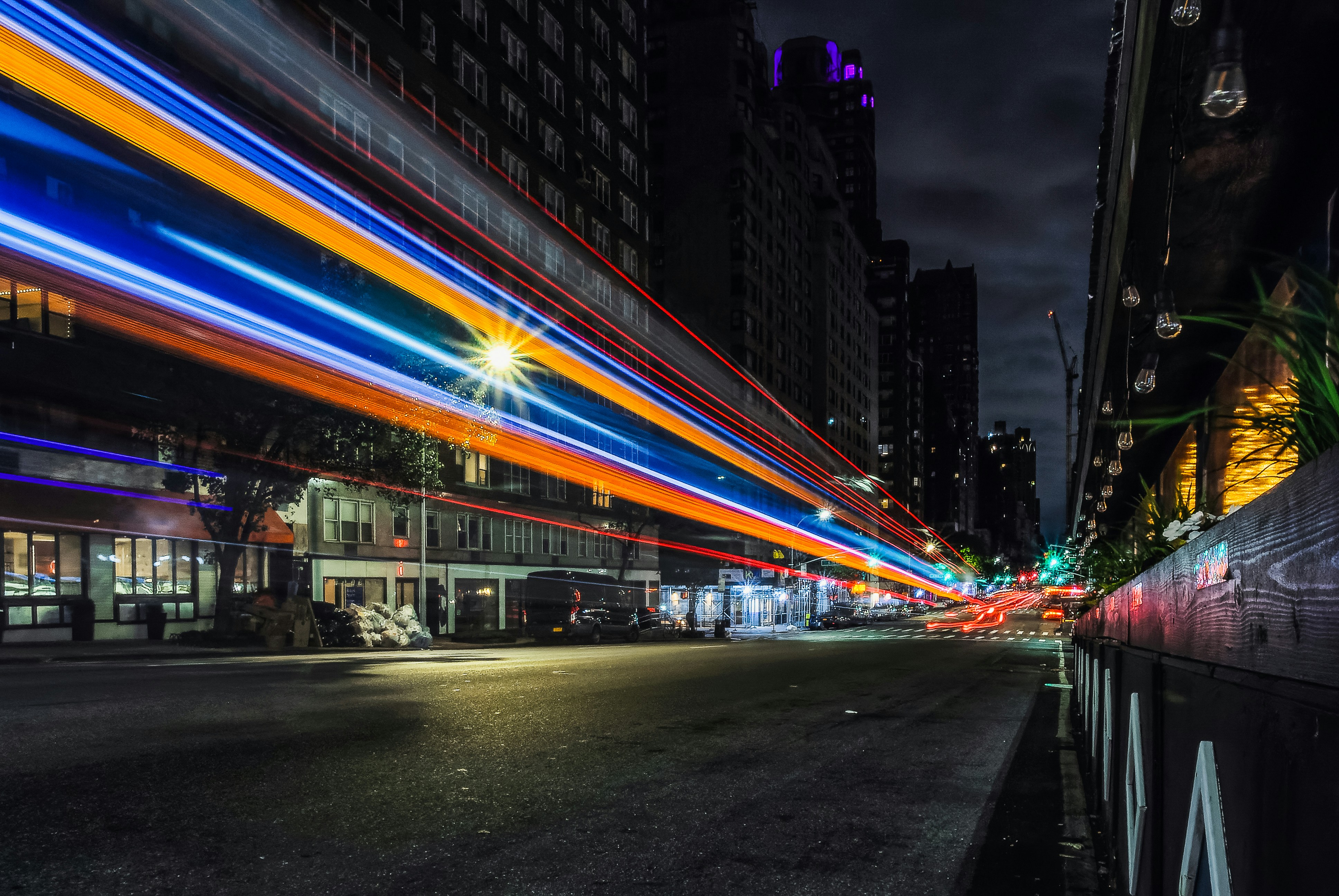 Long exposure of a bus streaking uptown on a deserted 3rd avenue at 3am in the middle of the night.