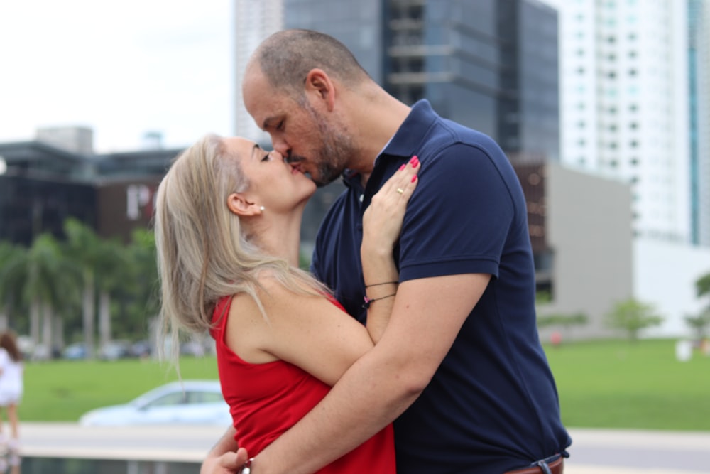 a man and a woman kissing in front of a fountain