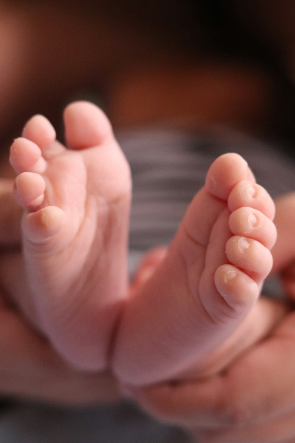 a close up of a person holding a baby's foot